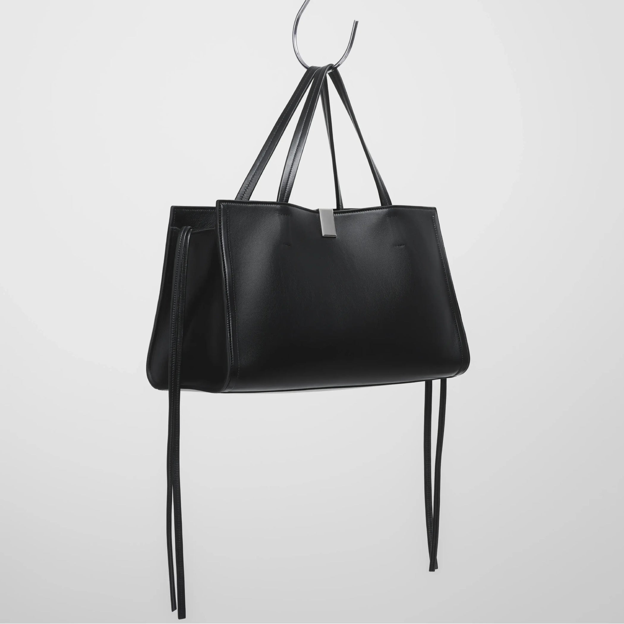 Angled view of medium kit cabas in black leather.