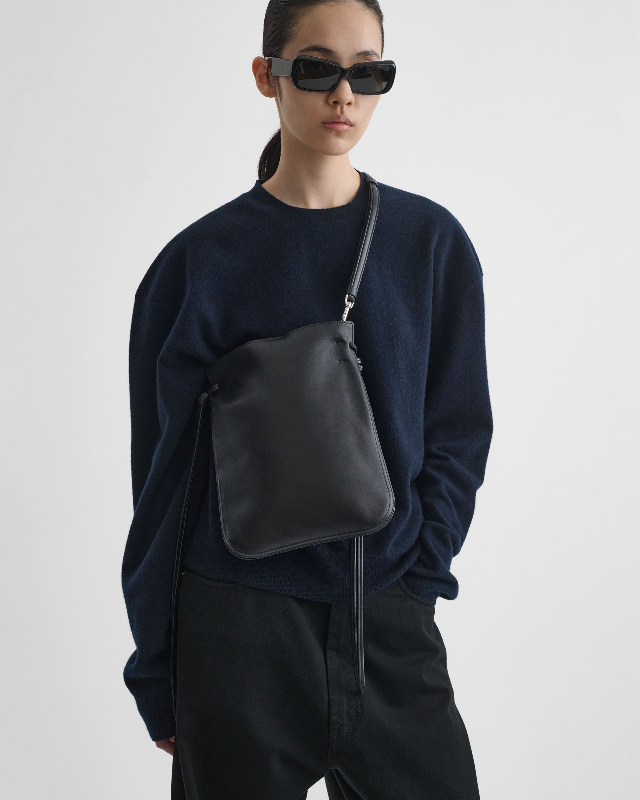 Front model view of the GIG POUCH BAG in black leather