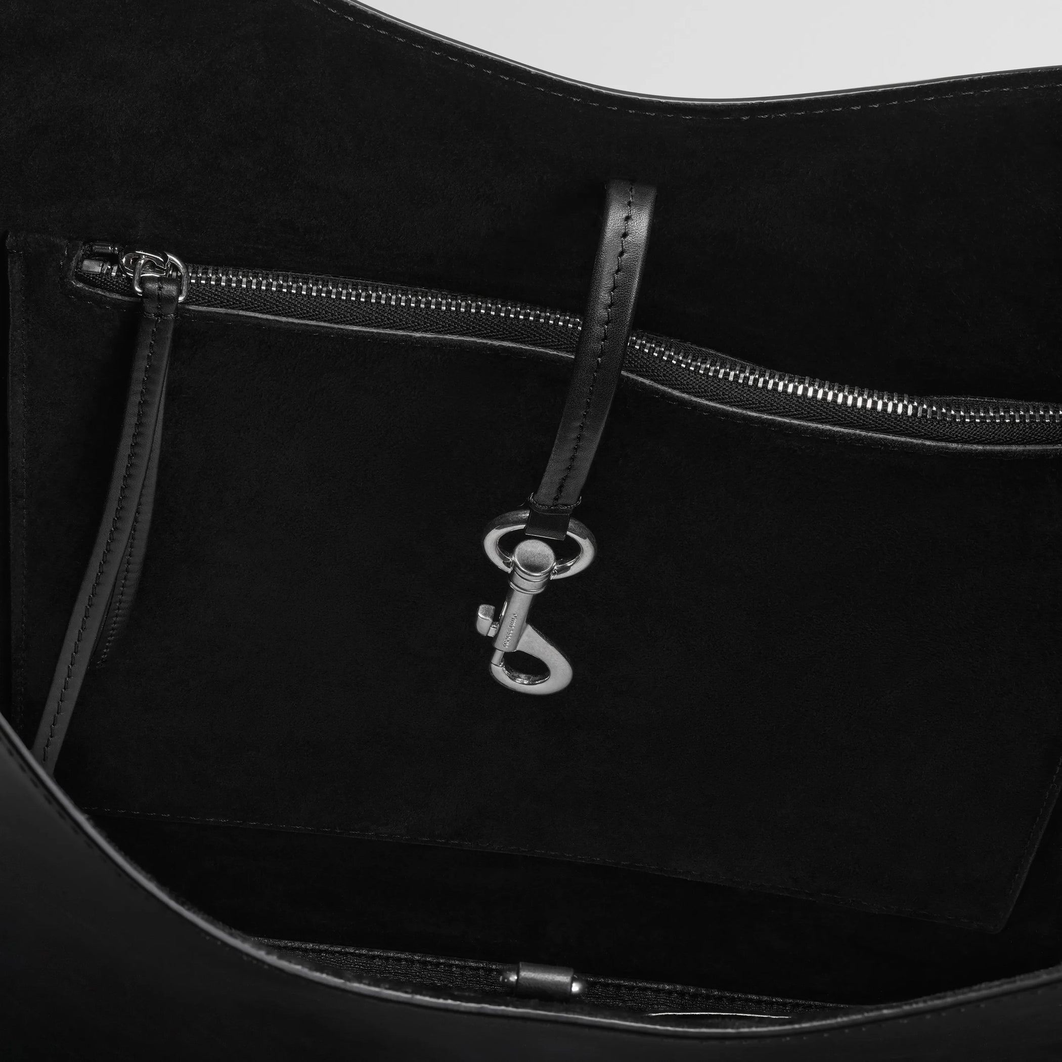 Detail view of bean sling bag in black leather.