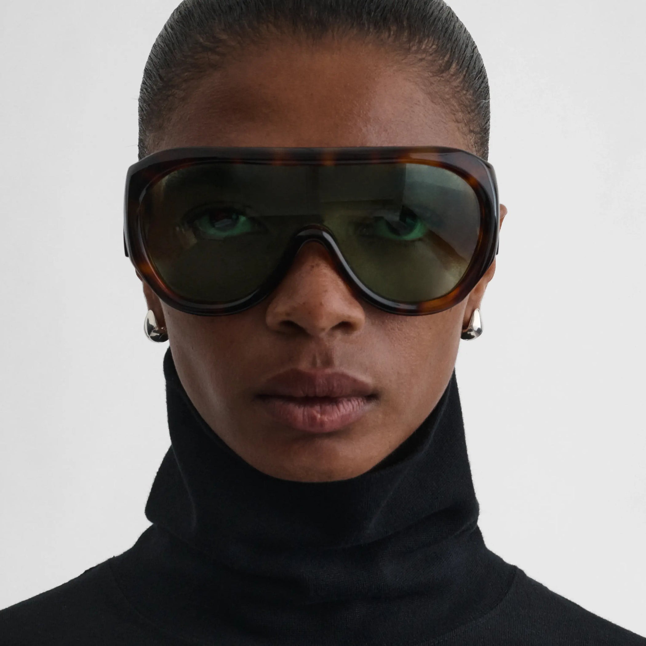 Front view of model wearing bombé sunglasses in cognac tortoiseshell acetate.