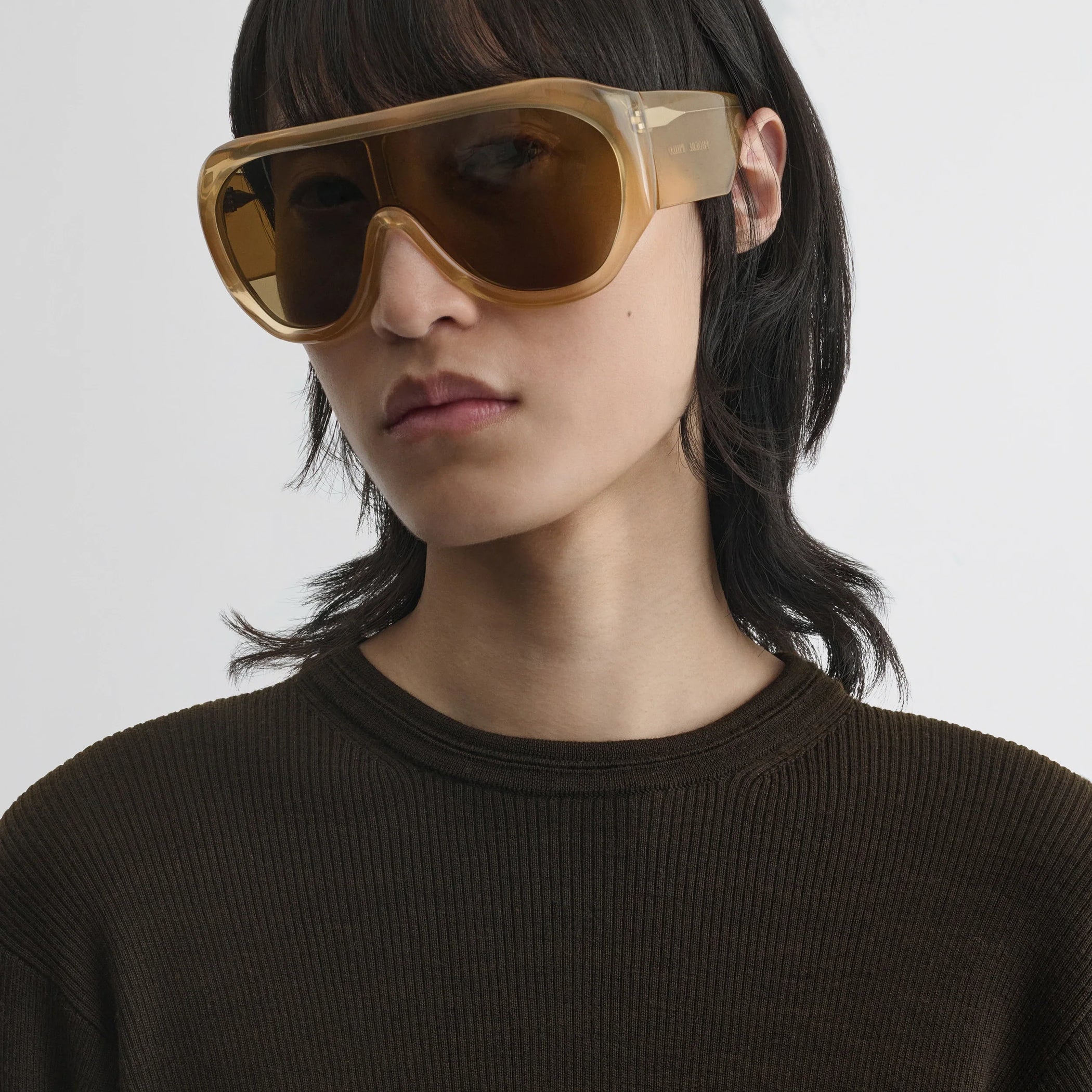 Side view of model wearing bombé sunglasses in caramel acetate.