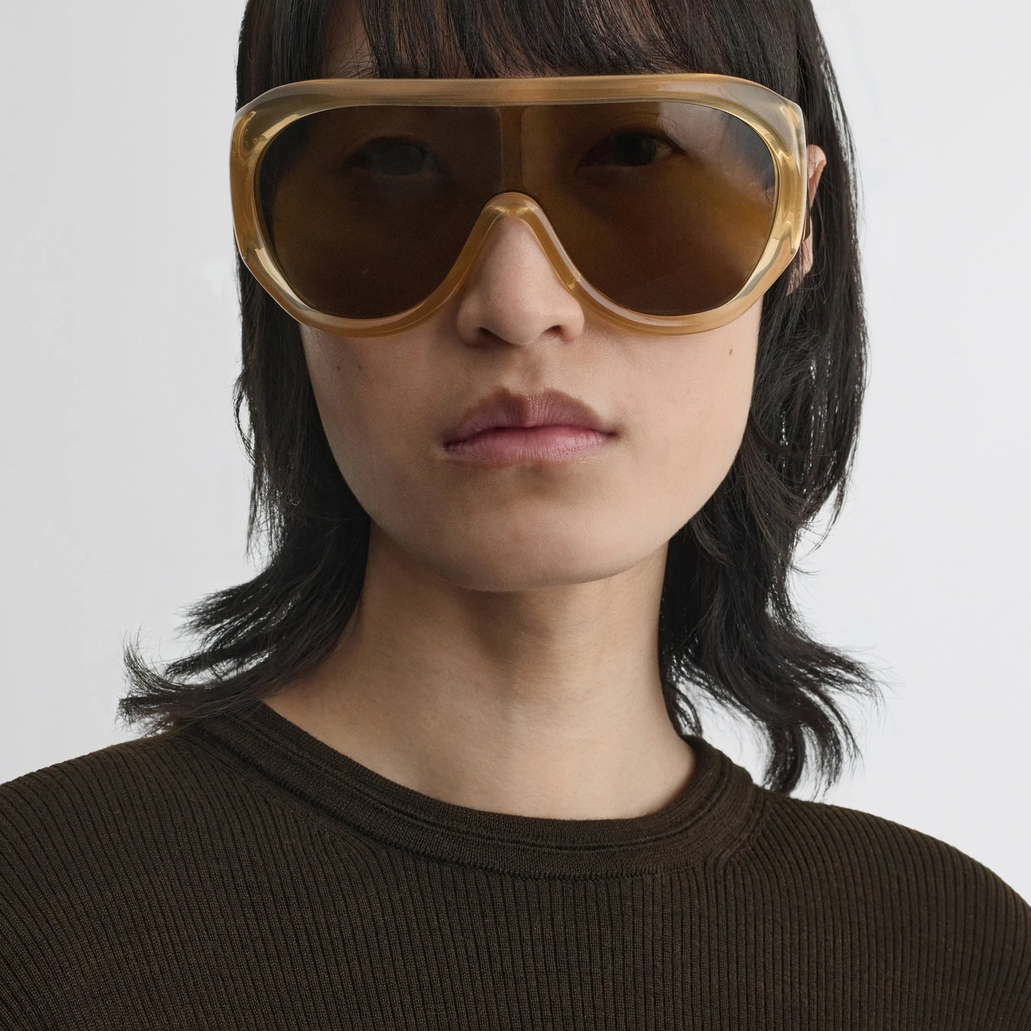 Front view of model wearing bombé sunglasses in caramel acetate.