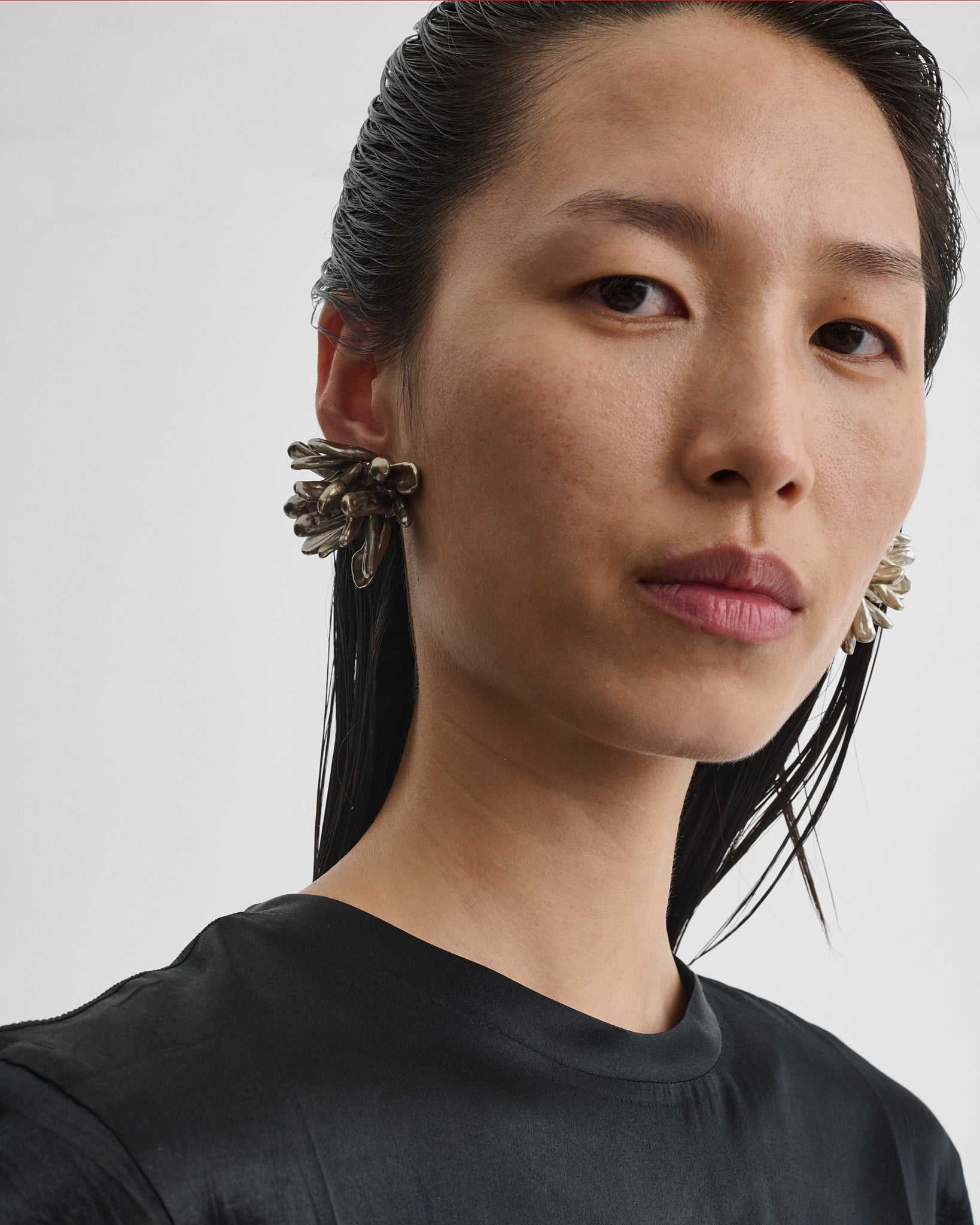 Front view of model wearing the CLUSTER EARRINGS in mink ash resin