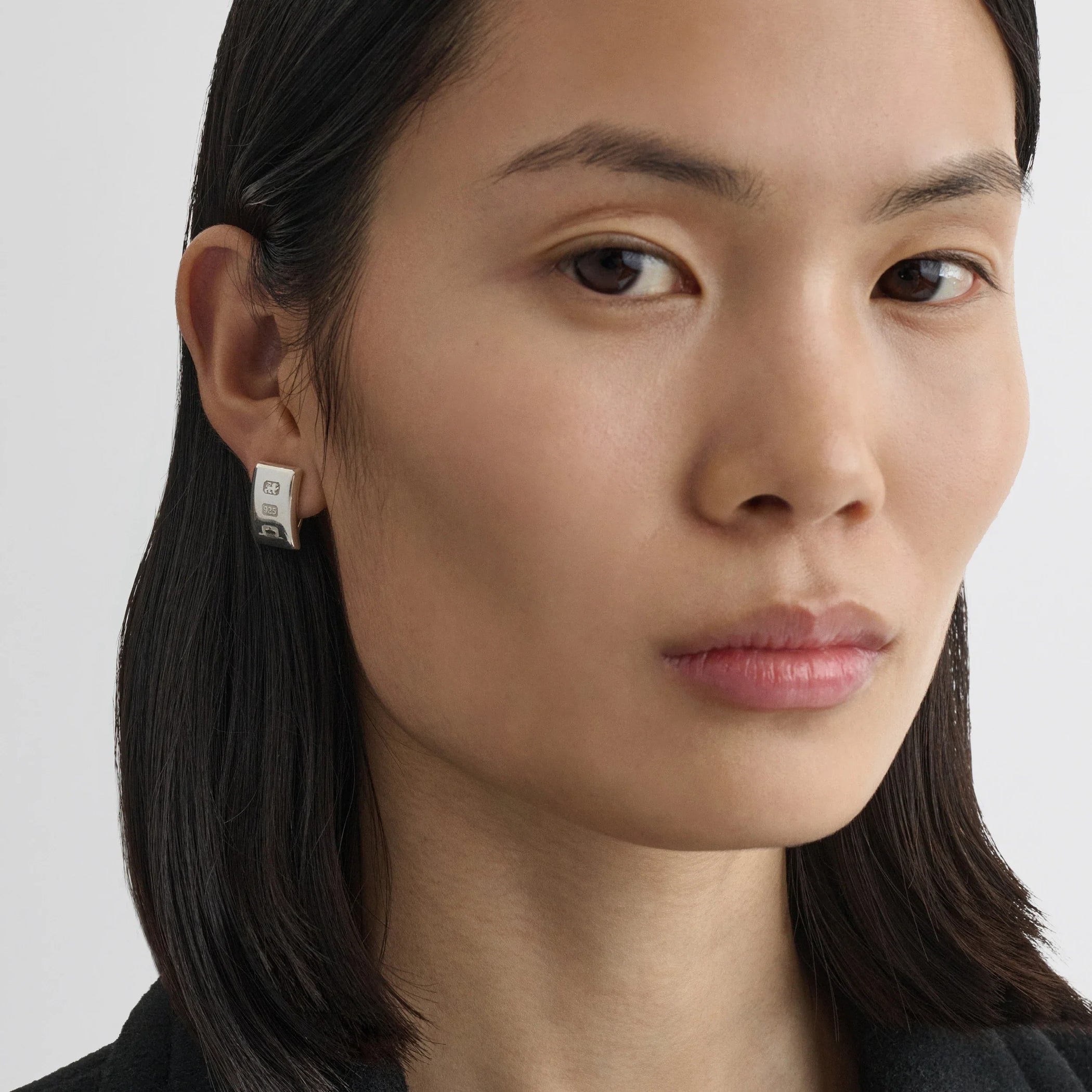 Front view of model wearing hallmark earrings in sterling silver.