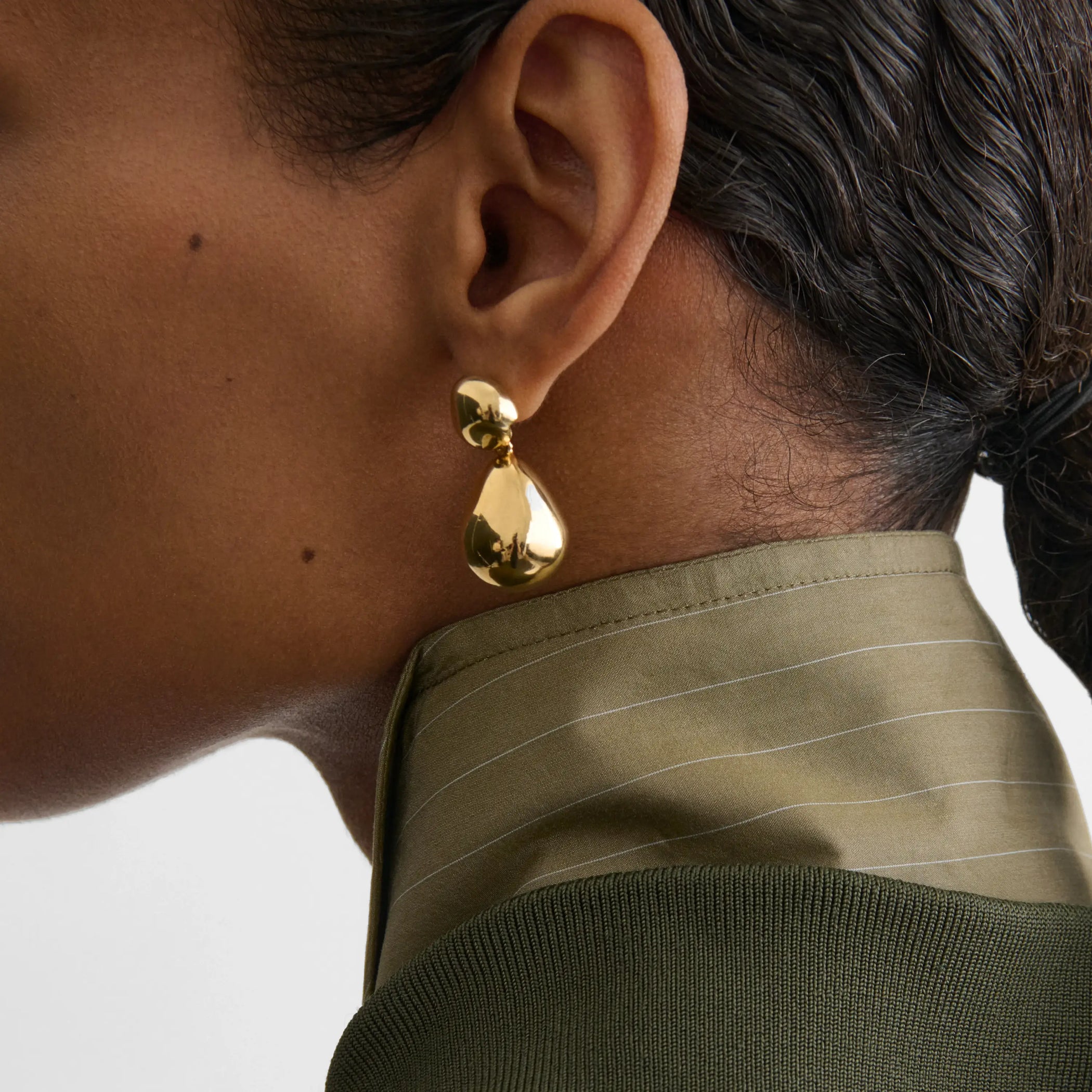 Side view of model wearing double ball earrings in gold plated sterling silver.
