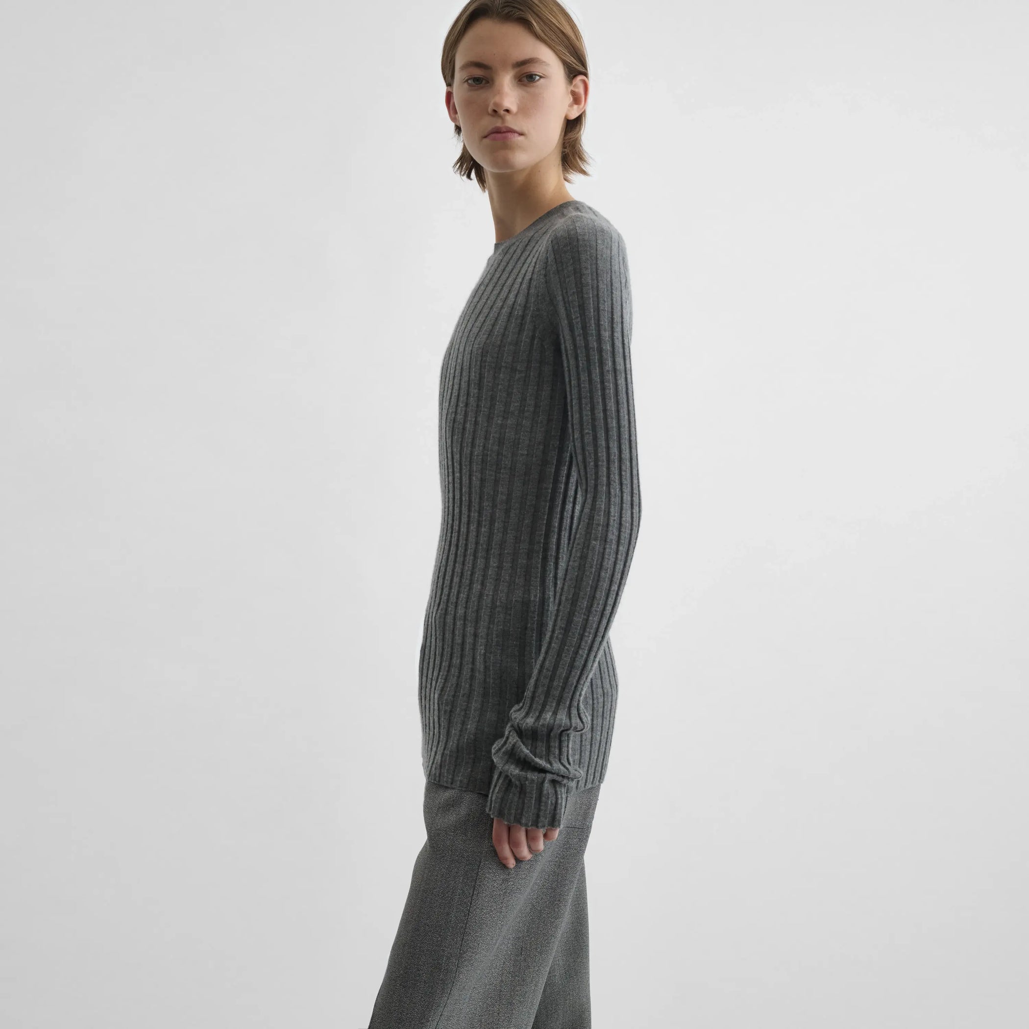 Side view of model wearing Wide Rib Crewneck in grey.