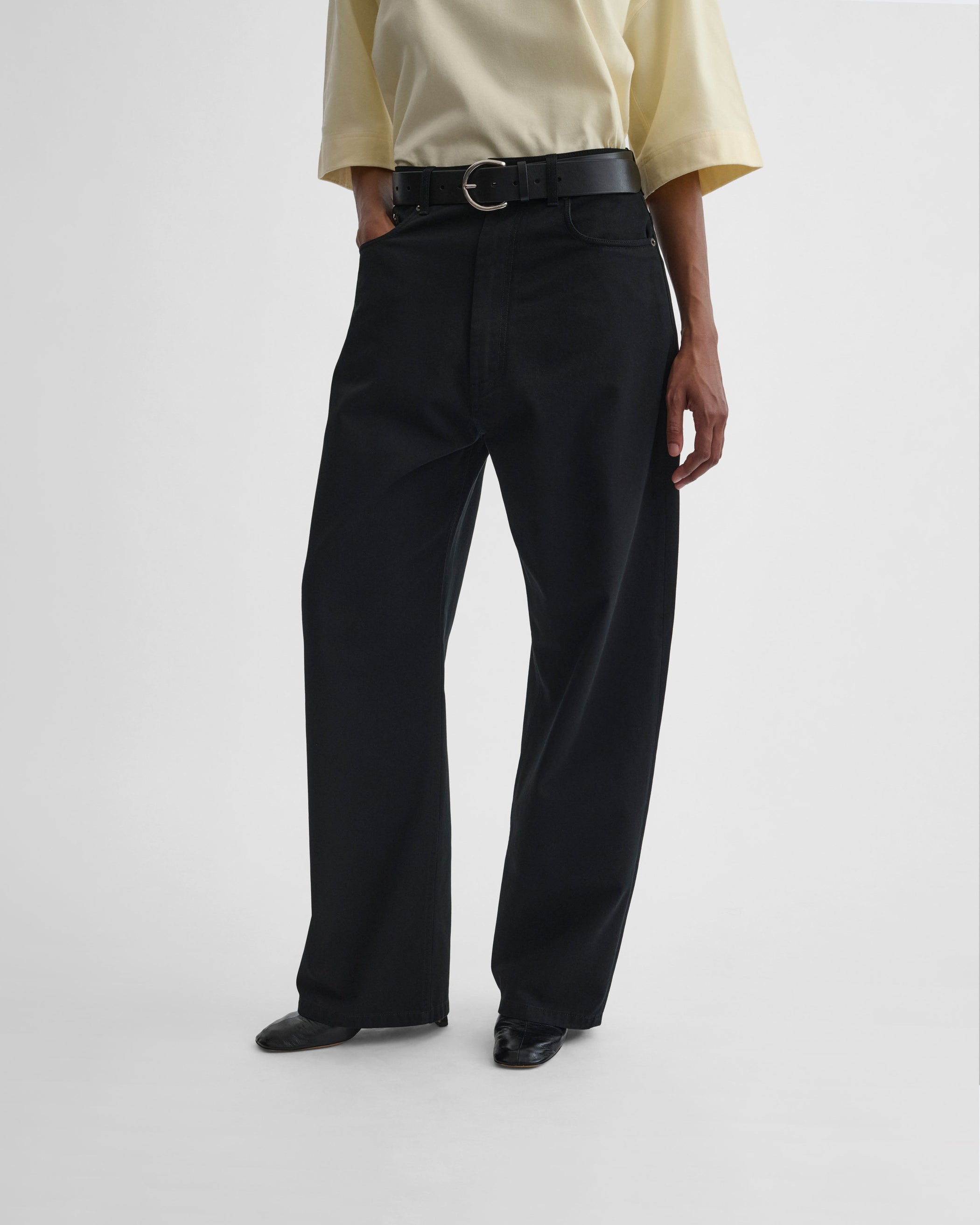 Front view of model wearing DROP JEANS in black cotton