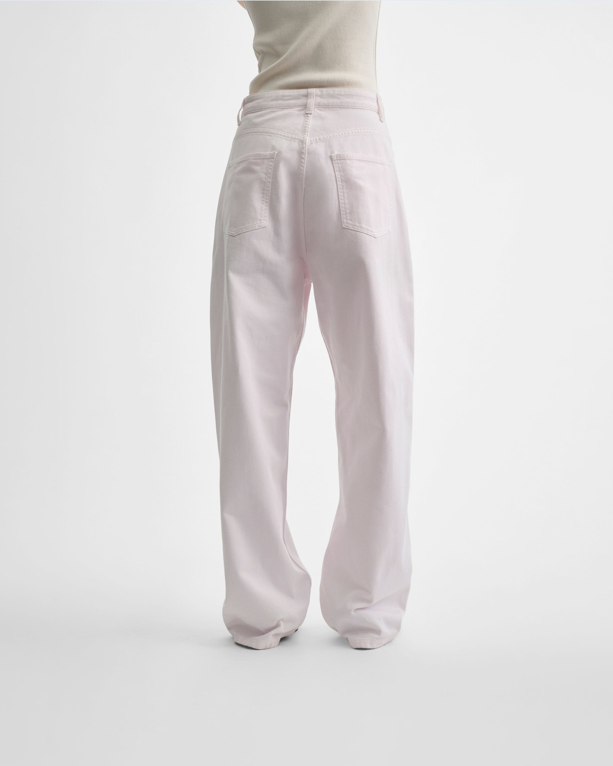 Back view of model wearing DROP JEANS in pale pink pink