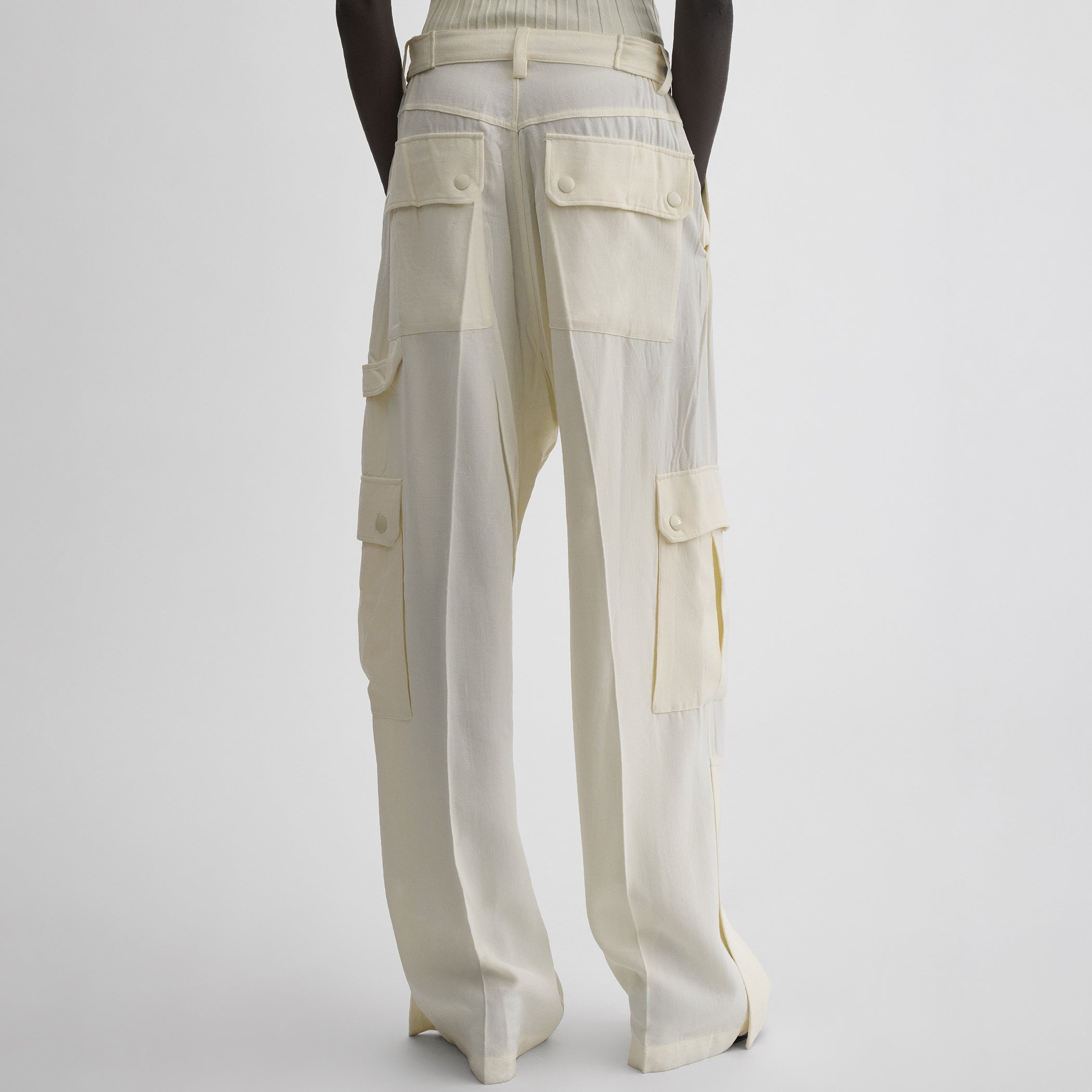 Back view of model wearing PATCH POCKET CARGO TROUSERS in parchment viscose silk