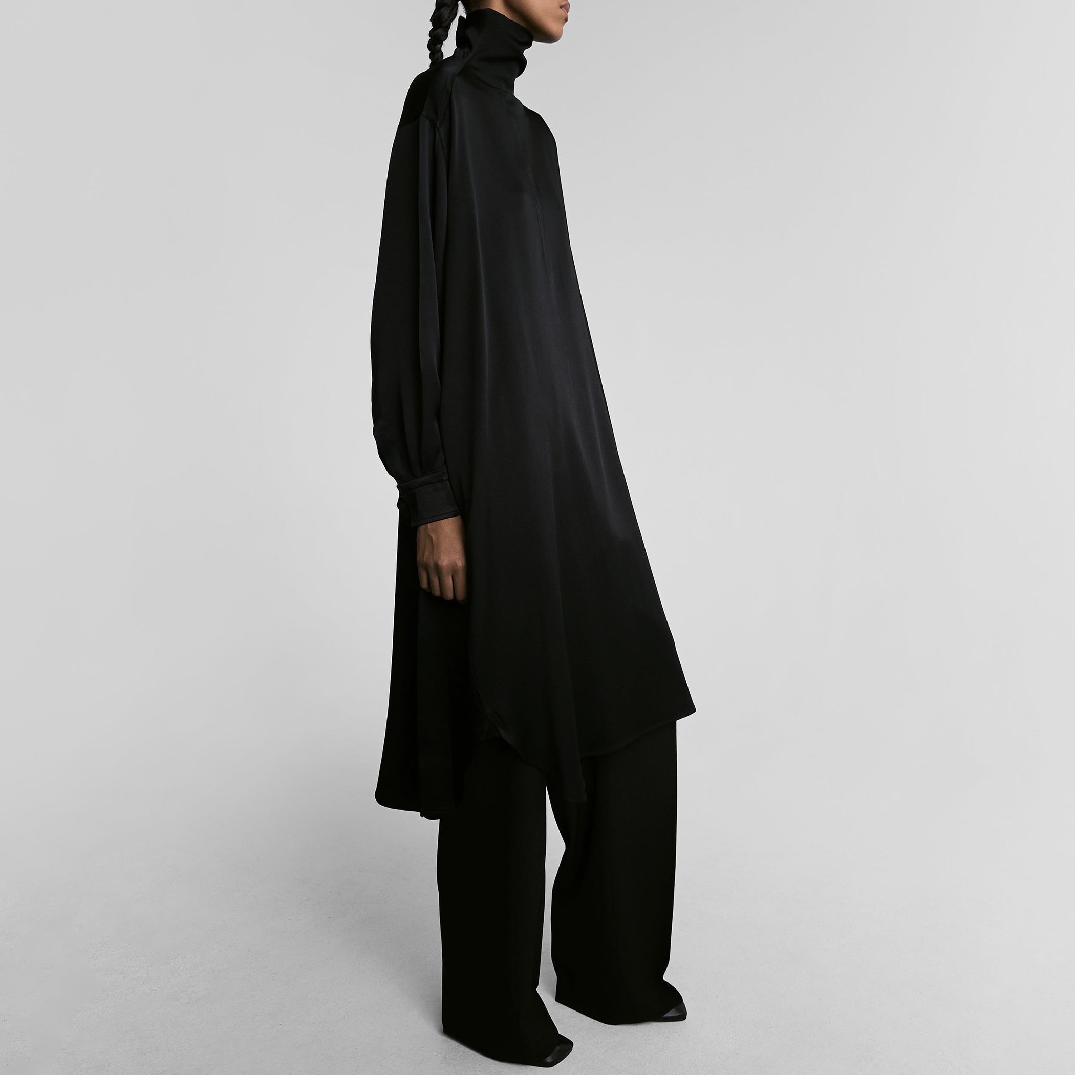 Side view of model wearing DRESS in black satin back crepe