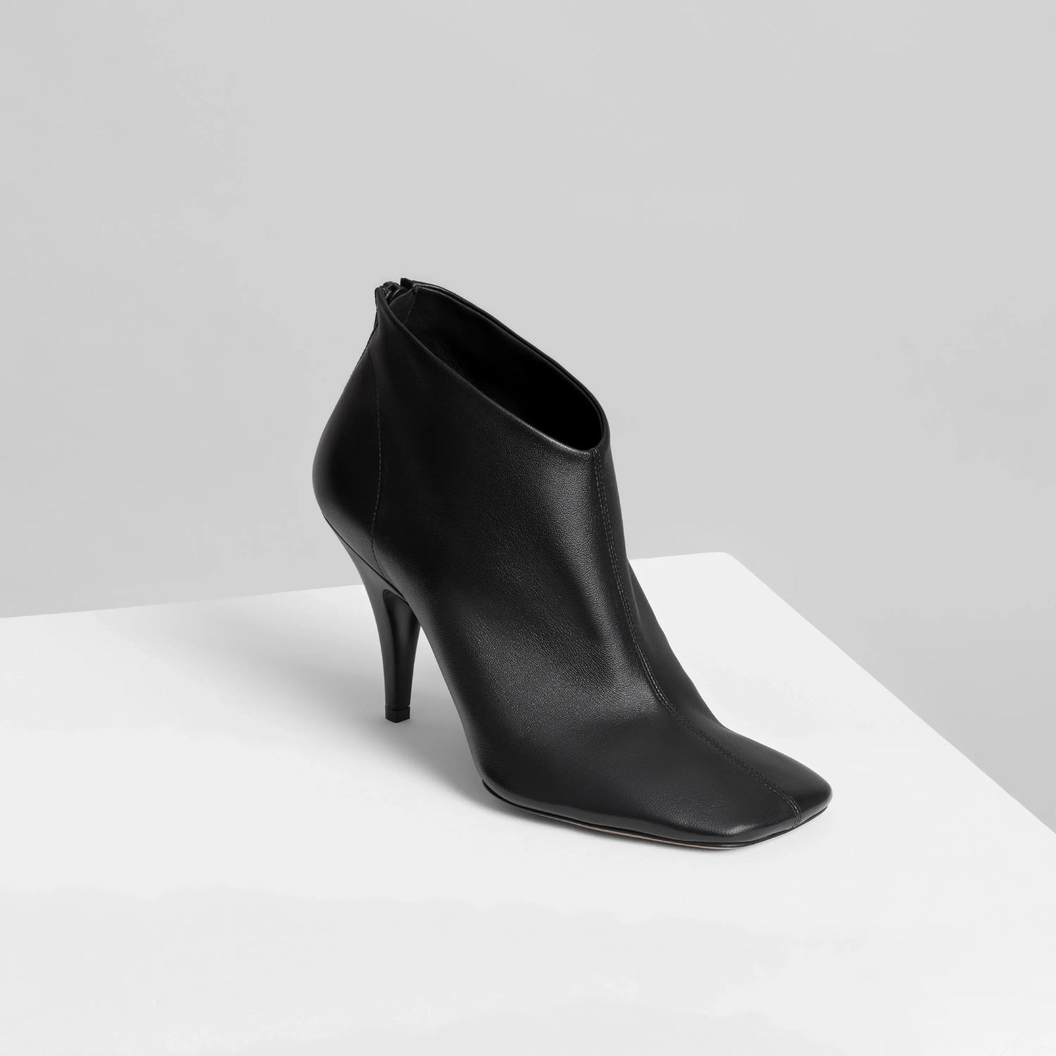 Angled view of soft ankle boot 90 in black leather.