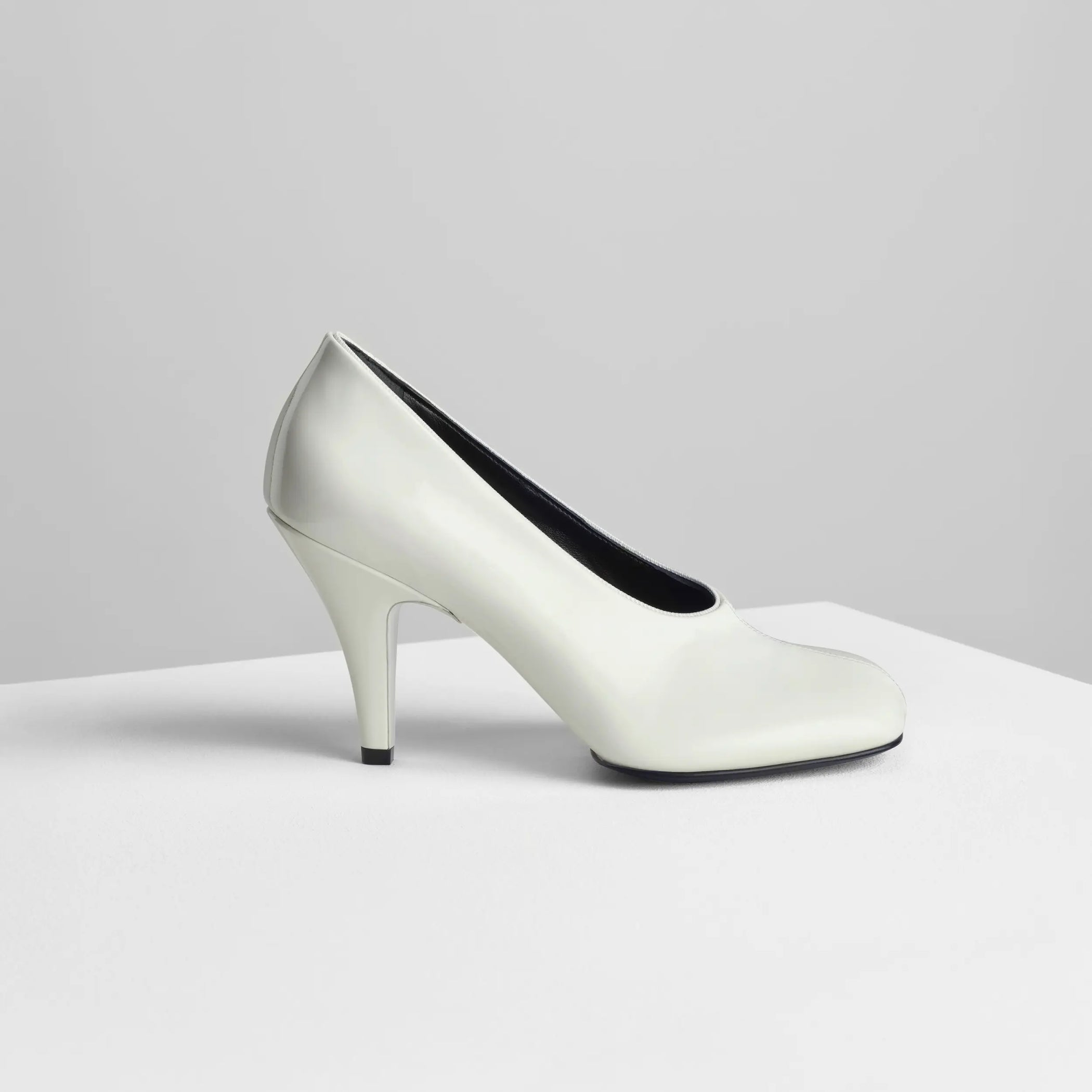 Side view of soft pump 90 in white patent leather