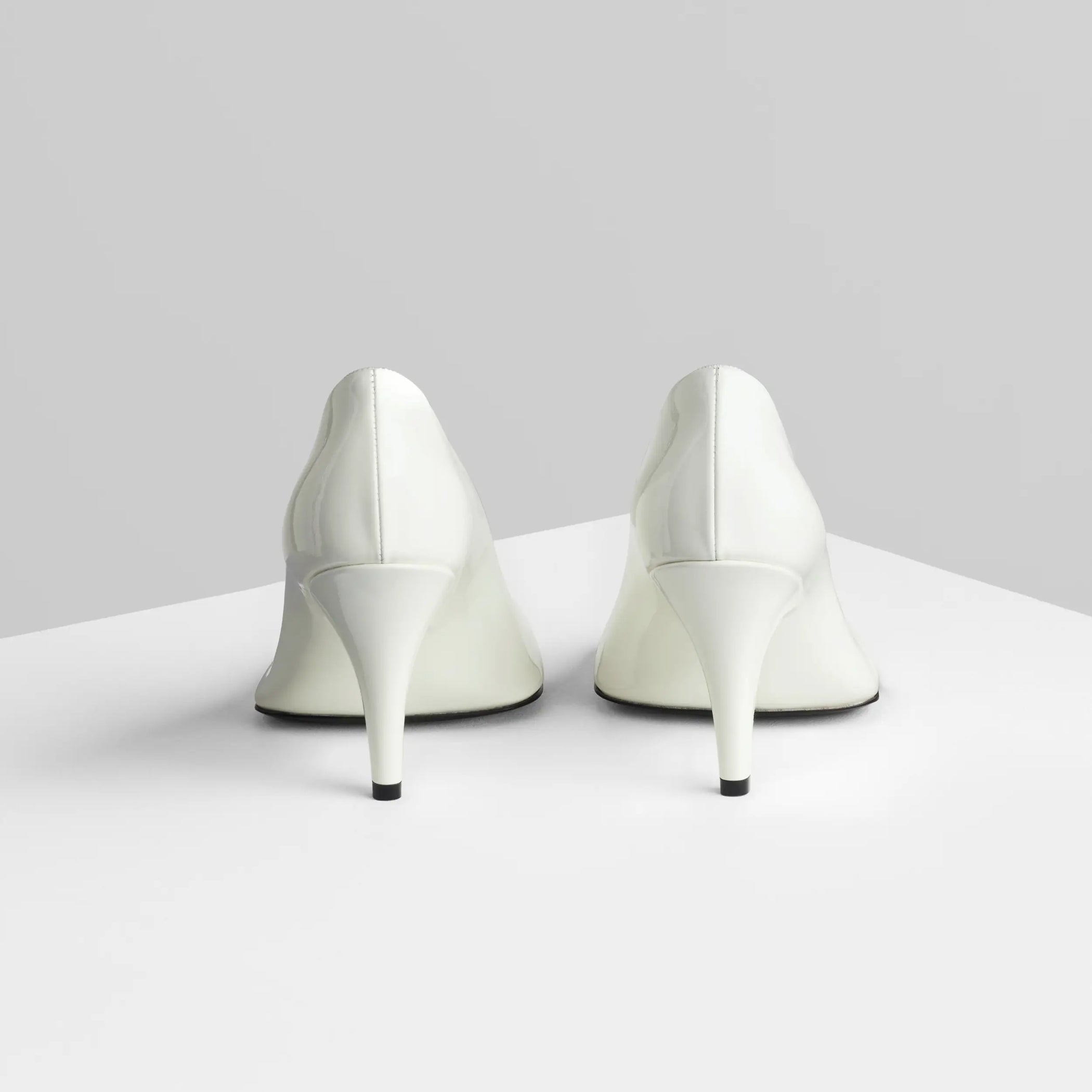 Back view of soft pump 90 in white patent leather