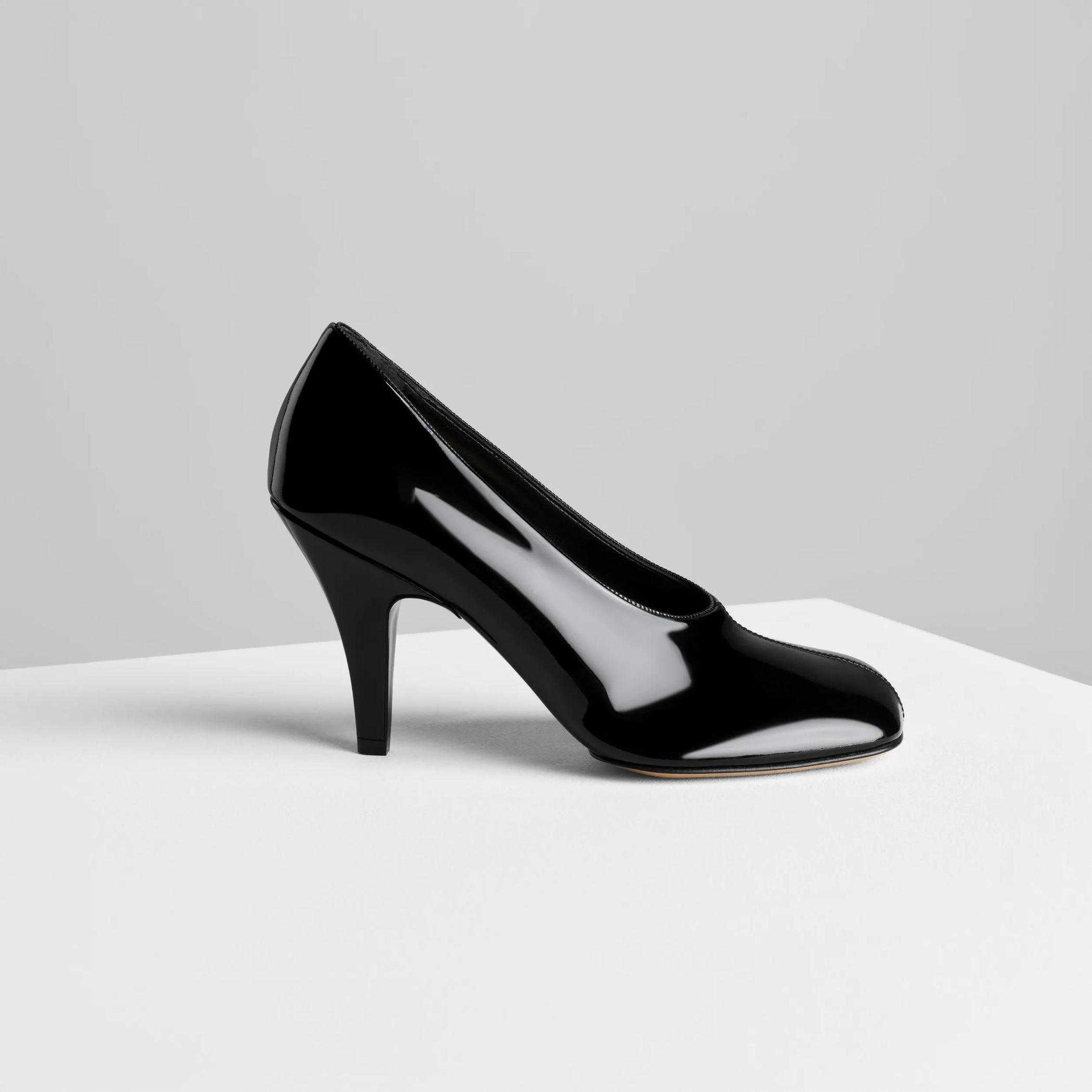 Side view of soft pump 90 in black patent leather.