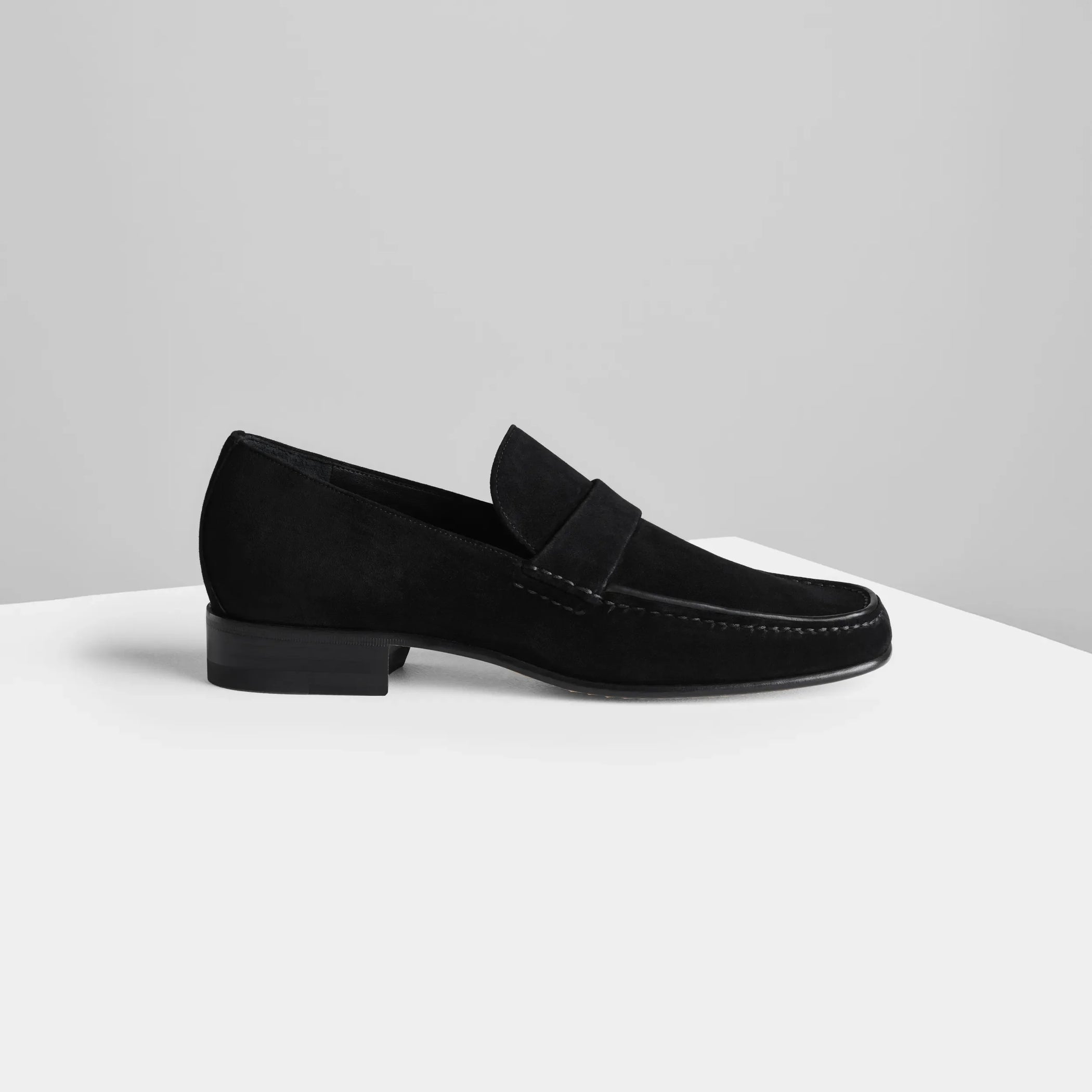 Side view of man&#39;s loafer in black suede leather.