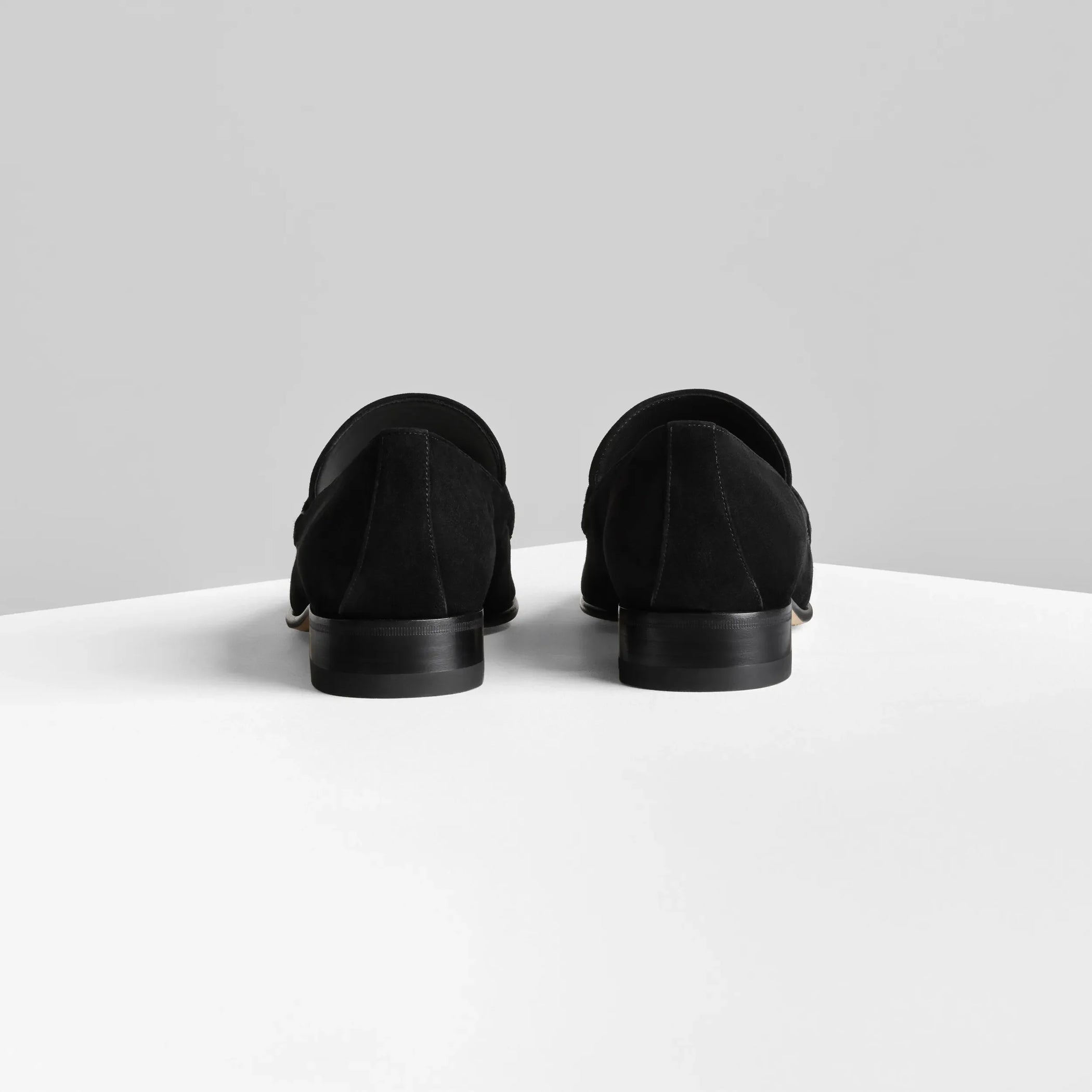 Back view of man&#39;s loafer in black suede leather.