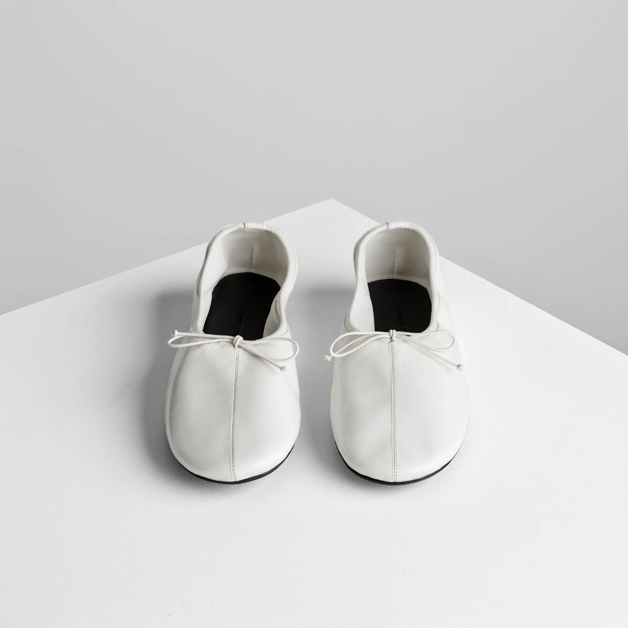 Front view of gathered flat in white leather.