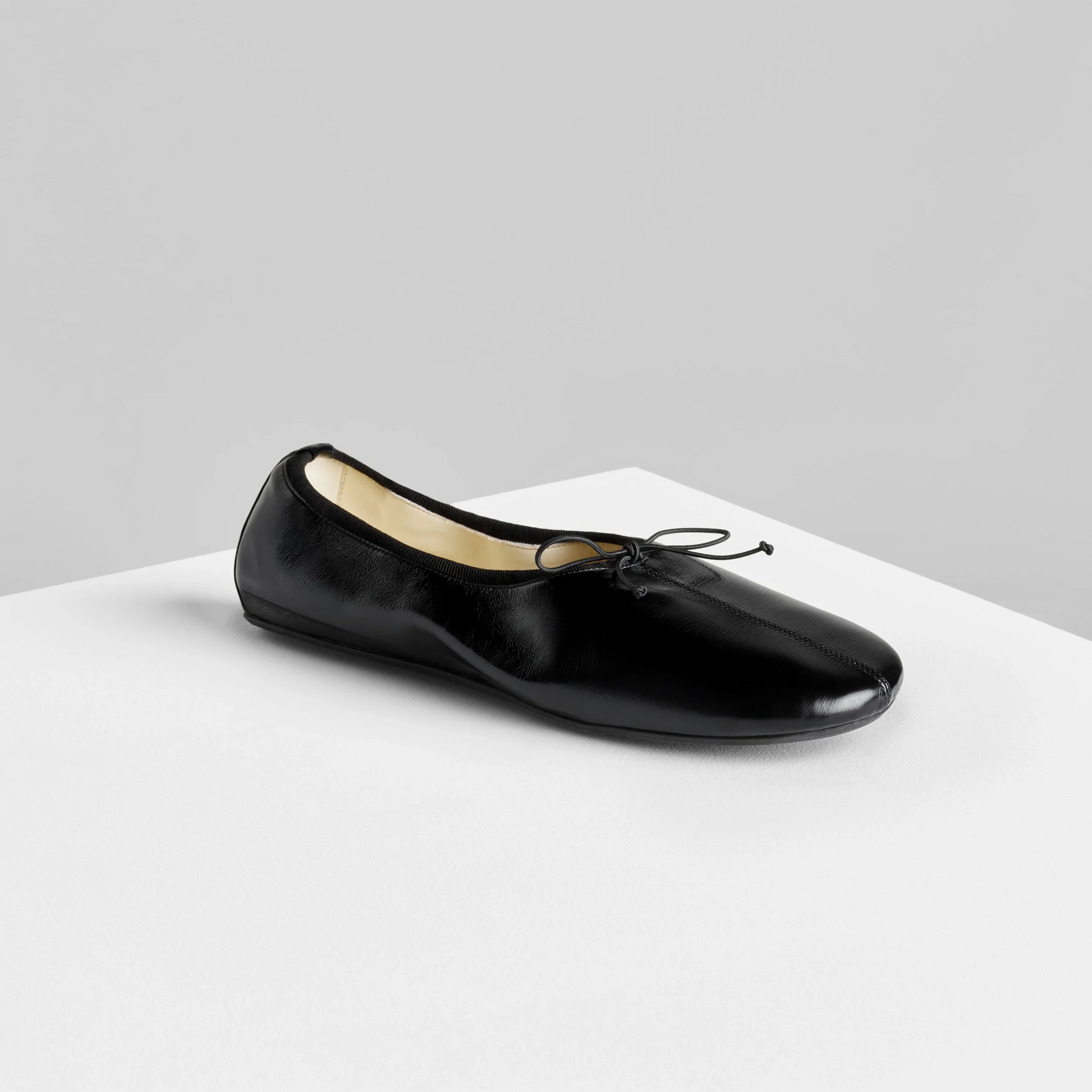 Side view of gathered flat in black leather.