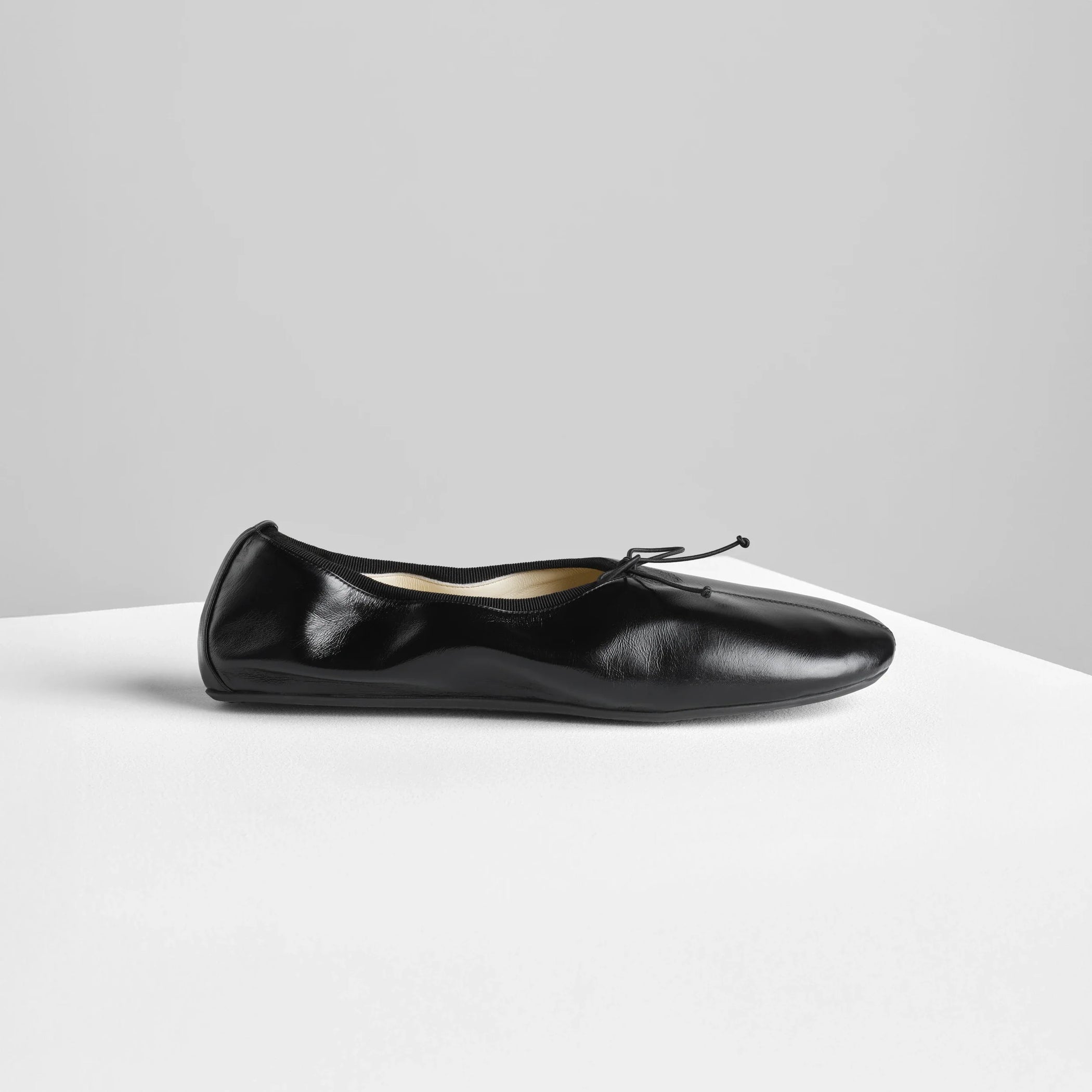 Side view of gathered flat in black leather.