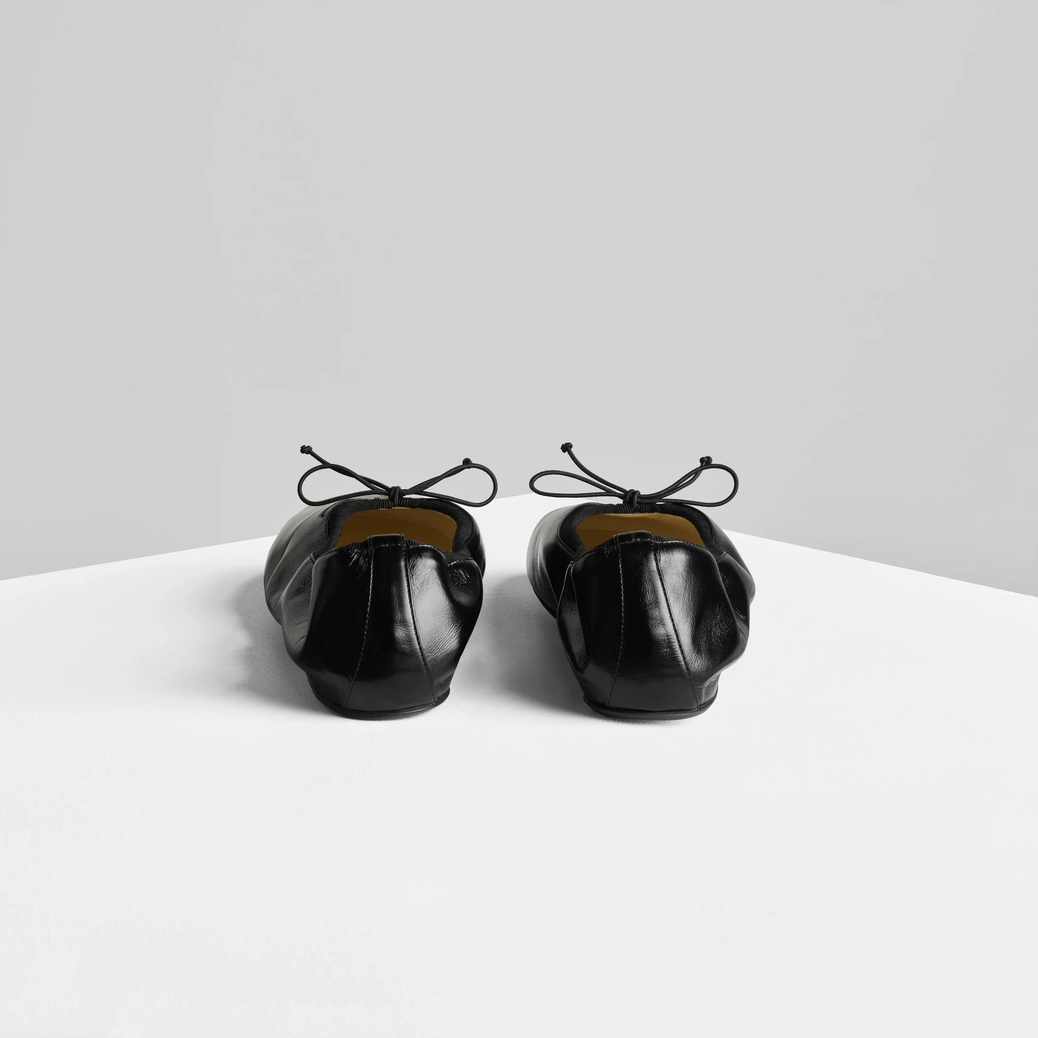 Back view of gathered flat in black leather.