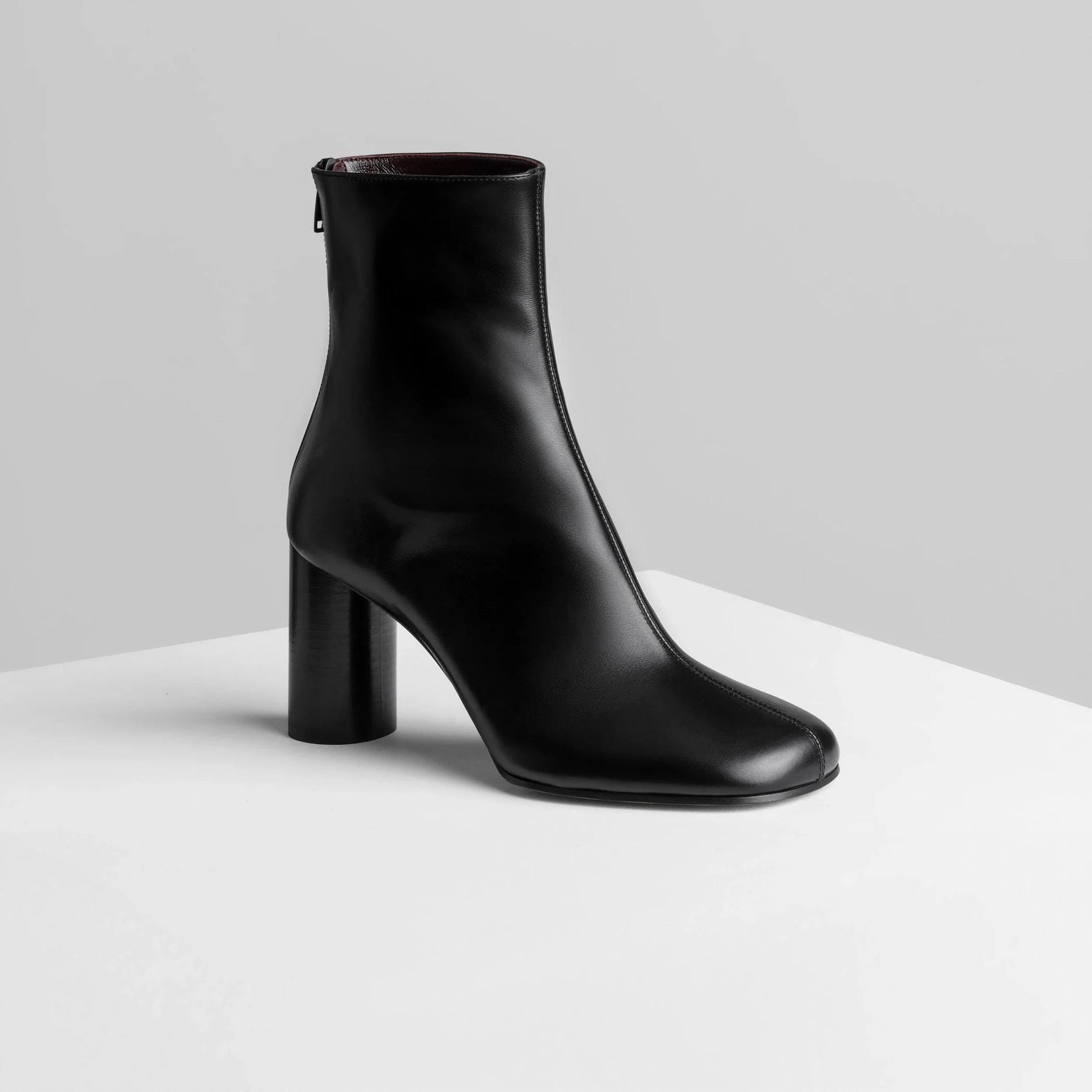 Side view of tug ankle boot in black leather.