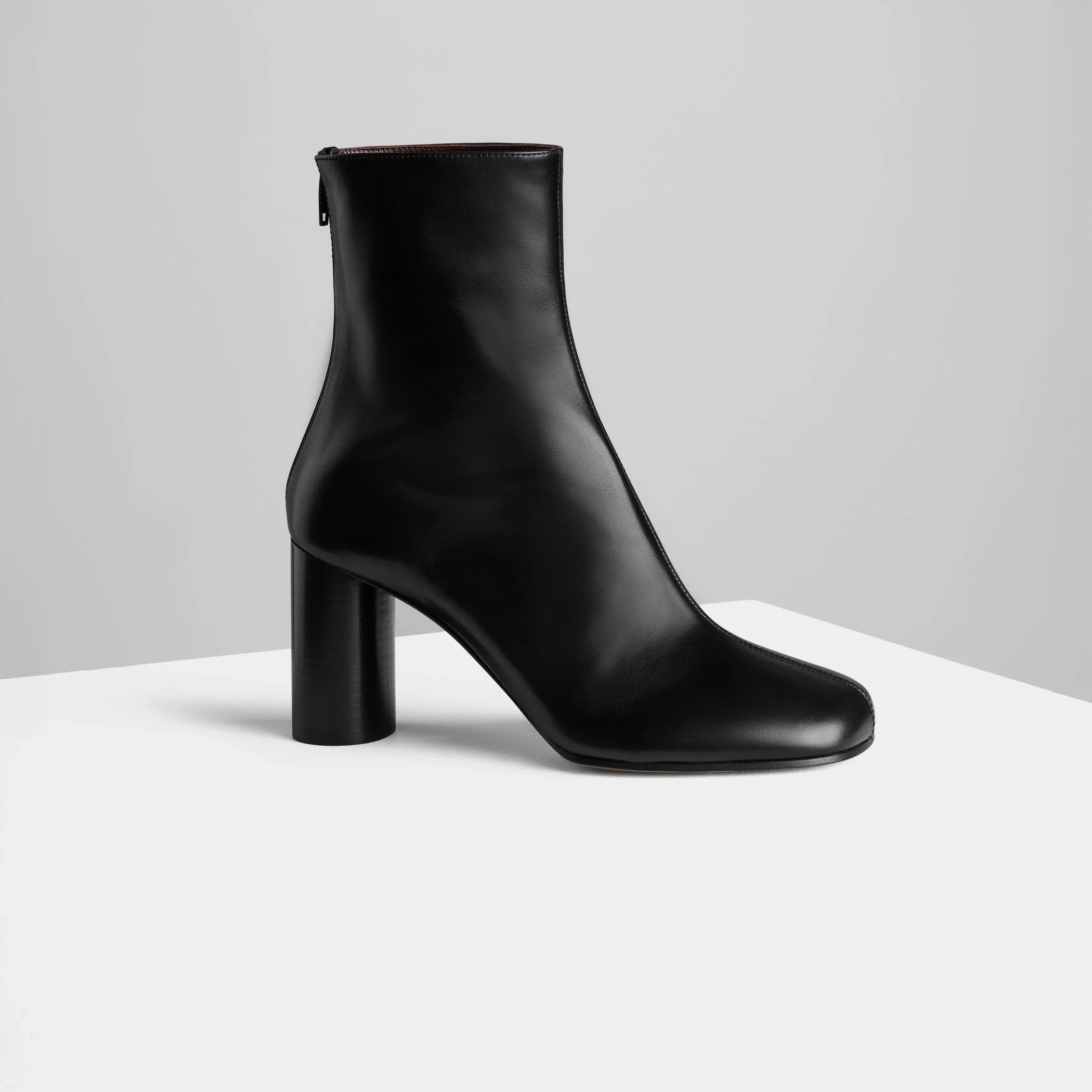 Side view of tug ankle boot in black leather.