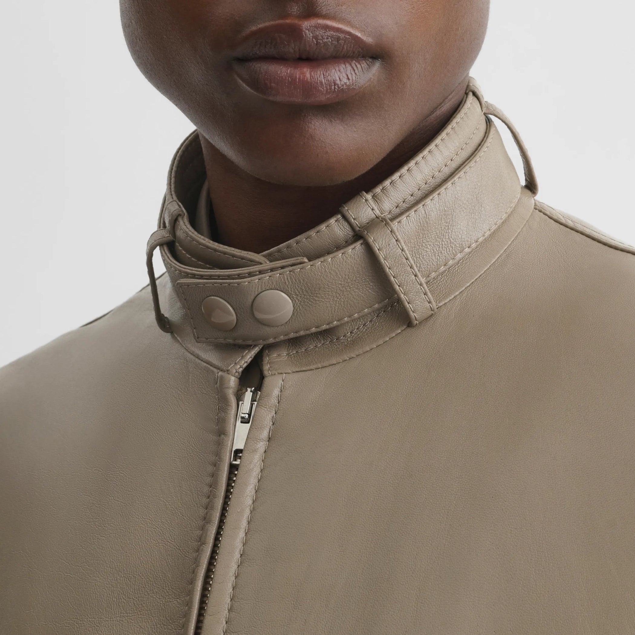 Close up detail view of jacket with attachable scarf in mastic leather