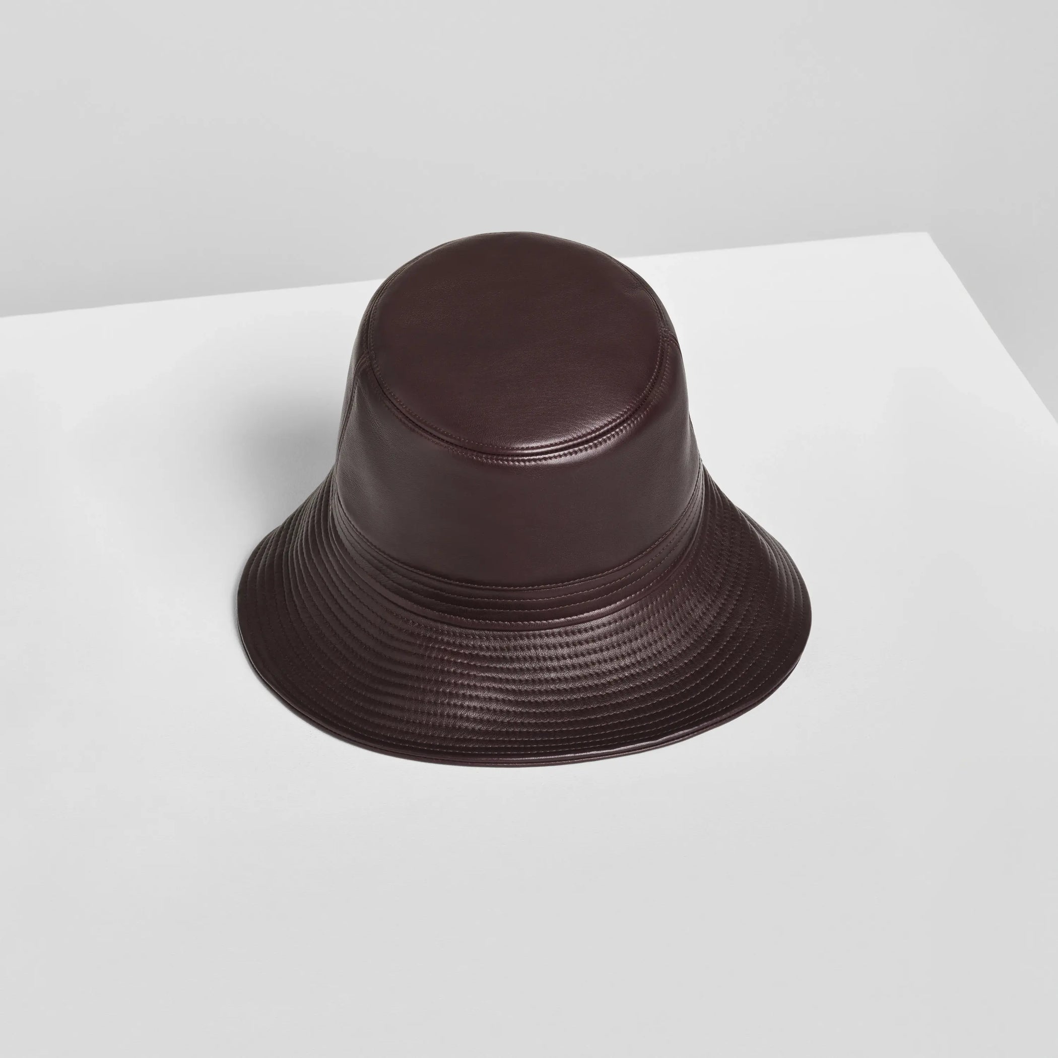 Flat front view of BUCKET HAT in dark berry leather