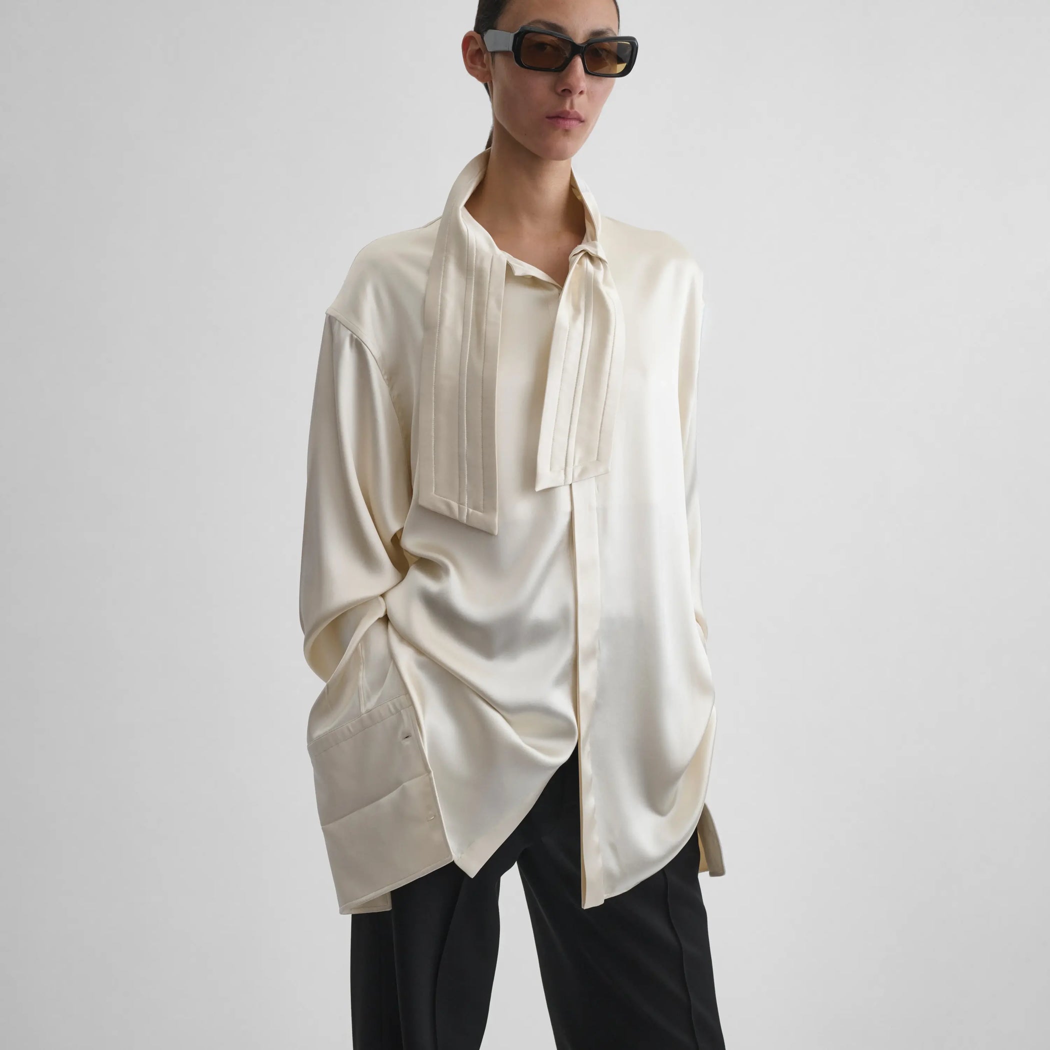 Front view of model wearing Tie Neck Shirt in cream.