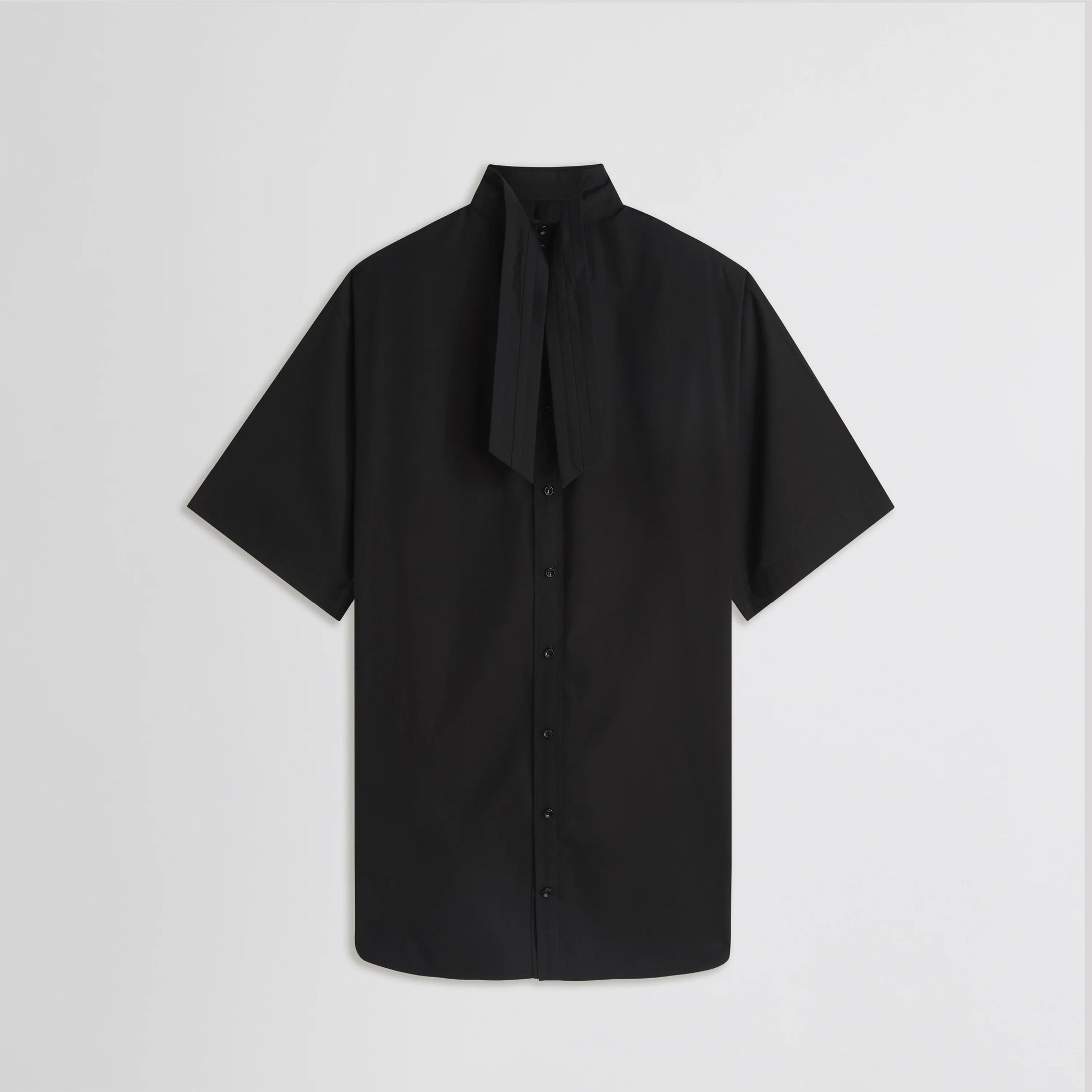 Flat back view of tie neck short sleeve shirt in black cotton
