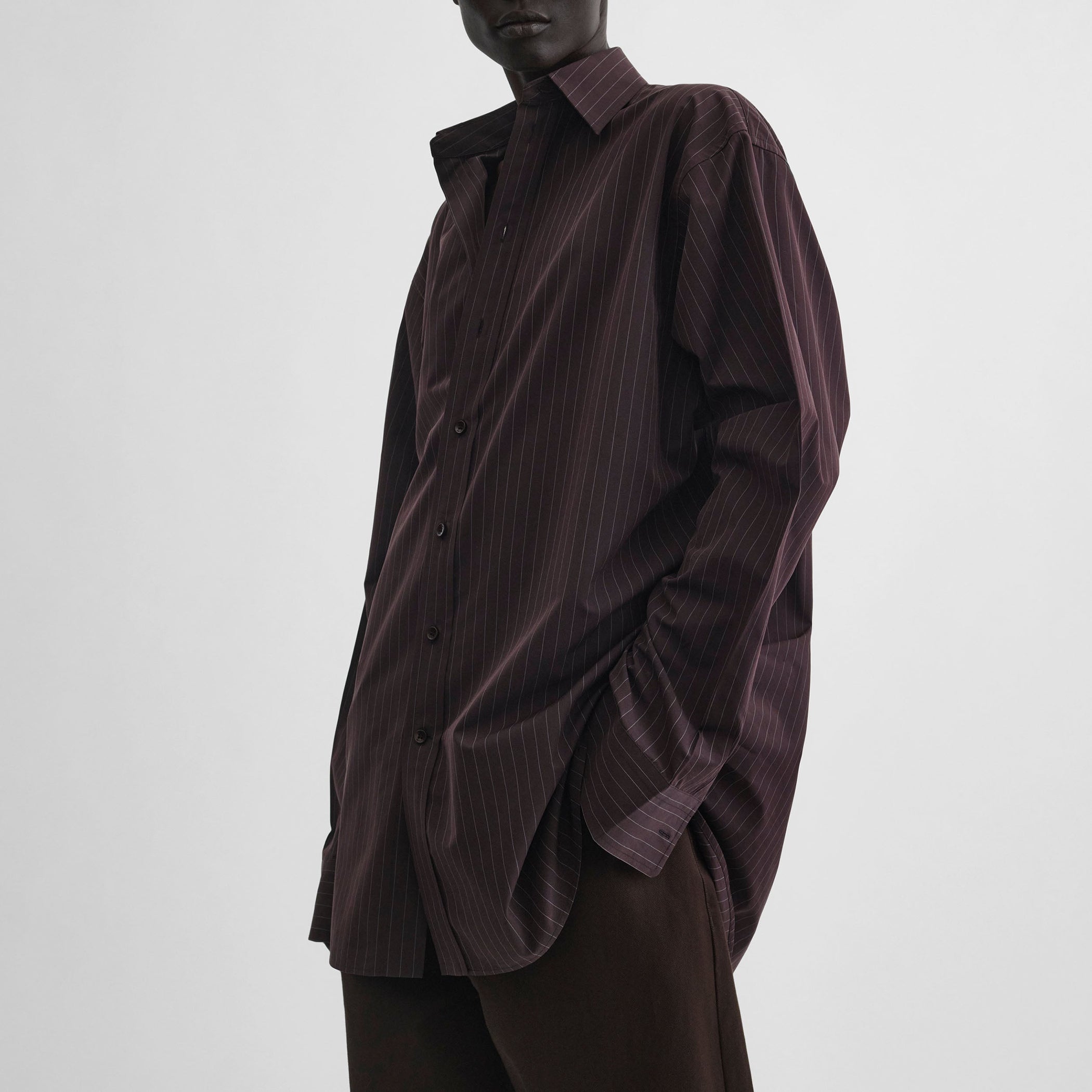 Side view of model wearing sharp collar shirt in black cherry pinstripe cotton