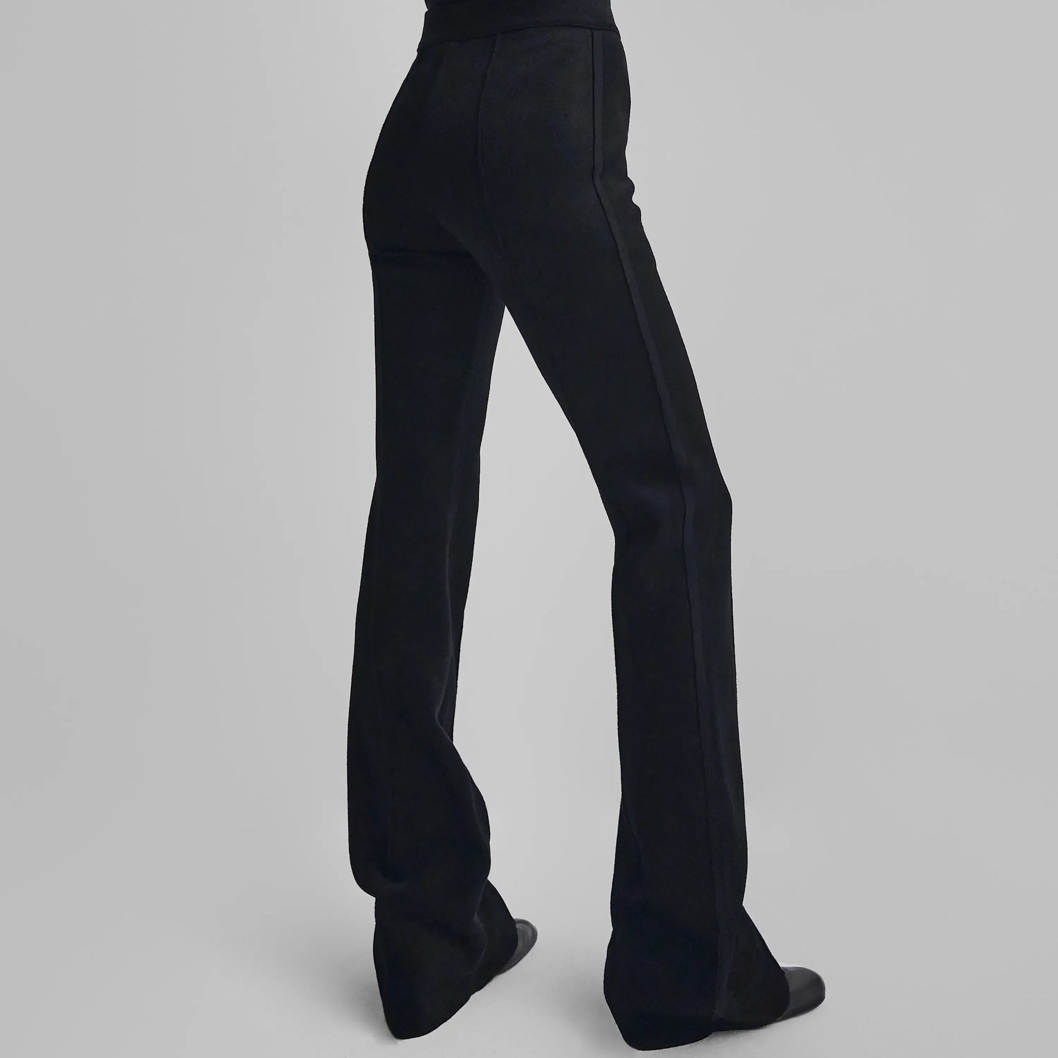 Back view of model wearing CHENILLE TROUSERS in black technical polyester