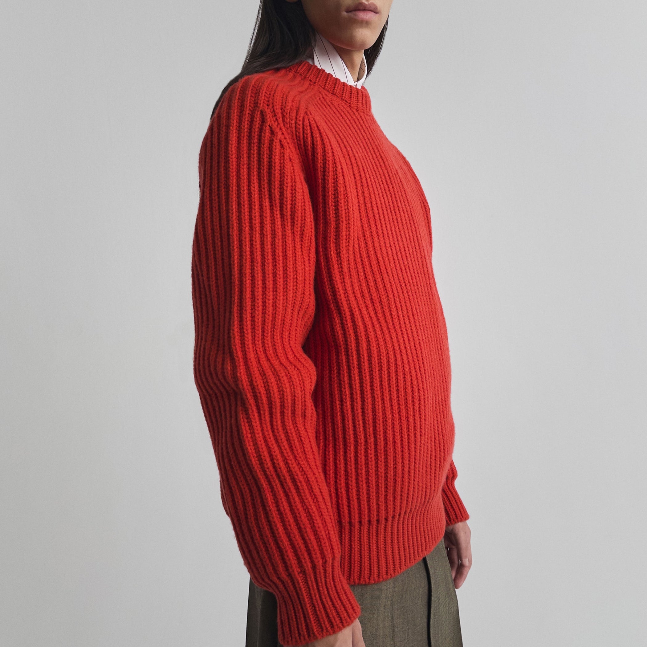Side view of model wearing CREW-NECK JUMPER in bright red english rib cashmere