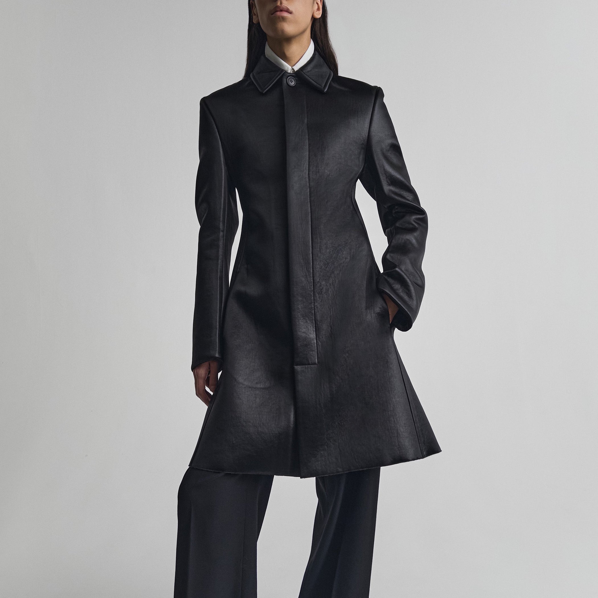 Front view of model wearing SHORT COAT in black bonded satin