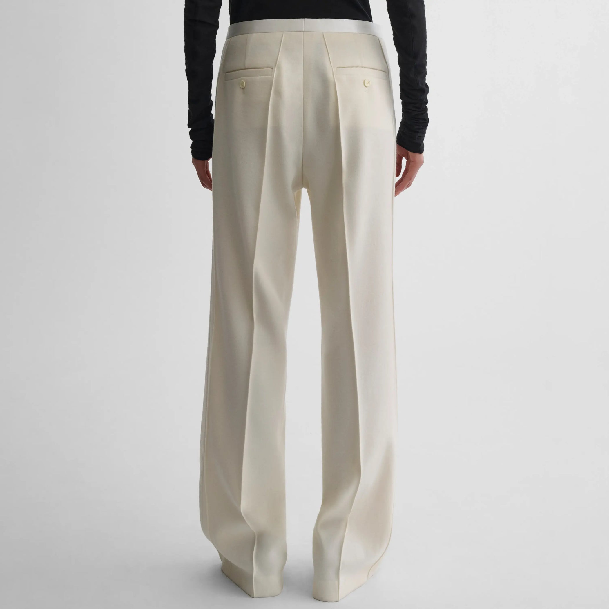Back view of model wearing Classic Tailored Trousers in cream.