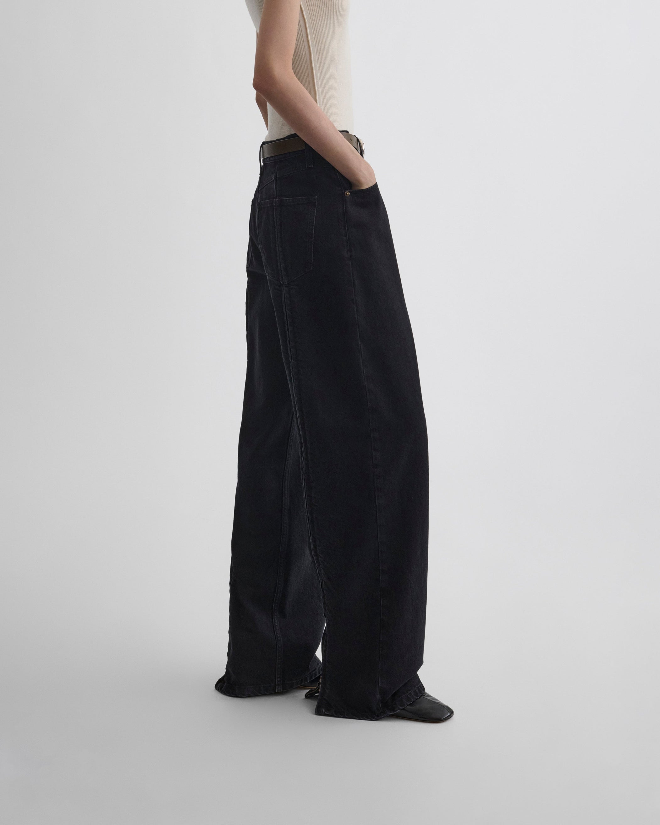Side view of model wearing ZIP JEANS in black cotton