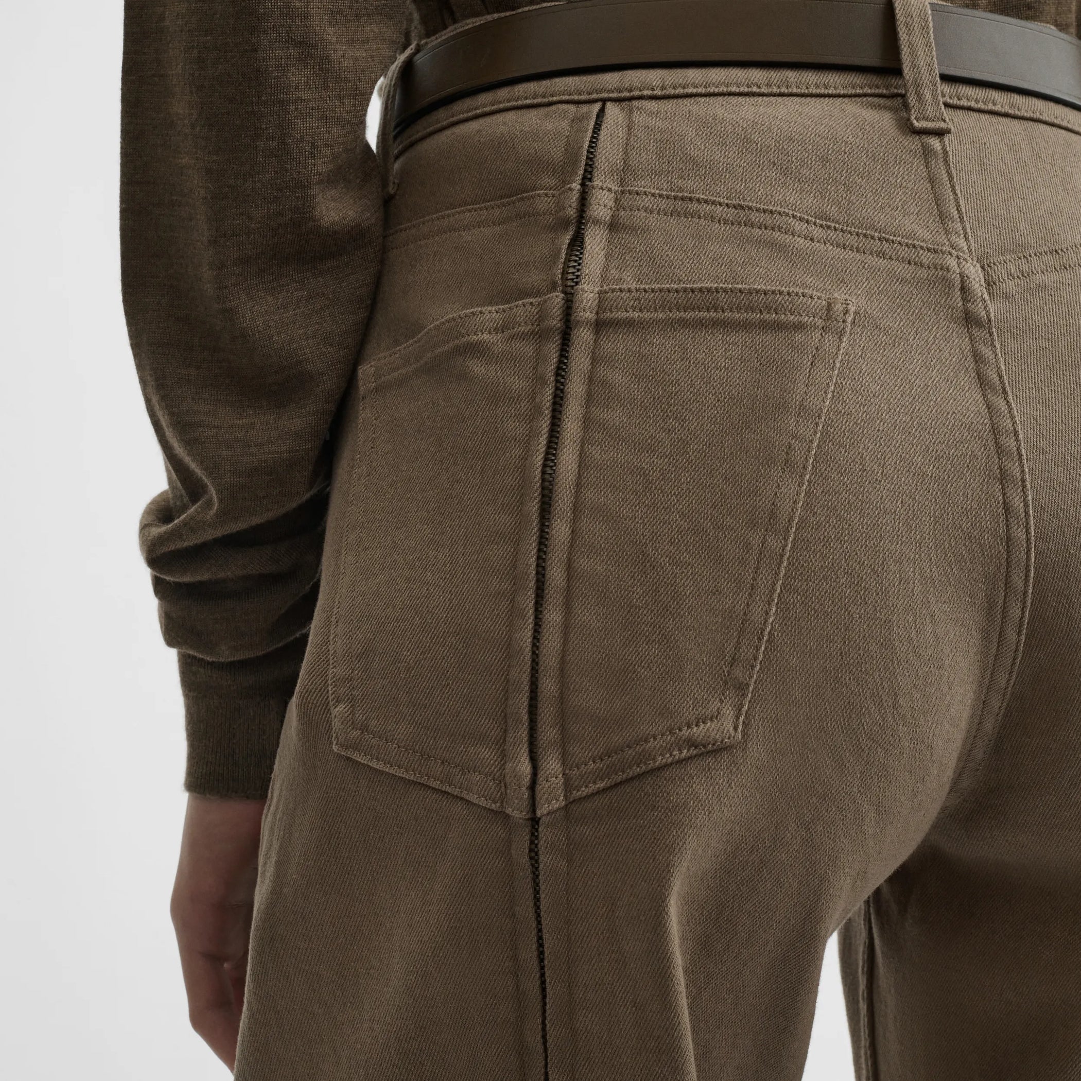 Close up detail view of zip jeans in warm khaki cotton
