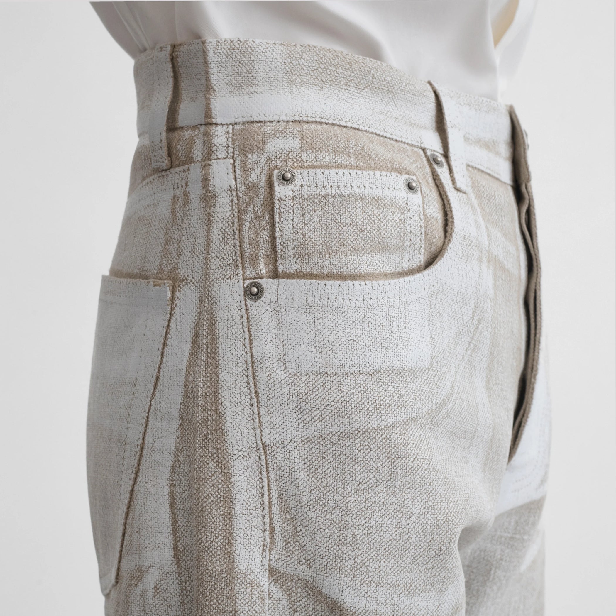 Side close up view of model wearing the classic jeans in hay
