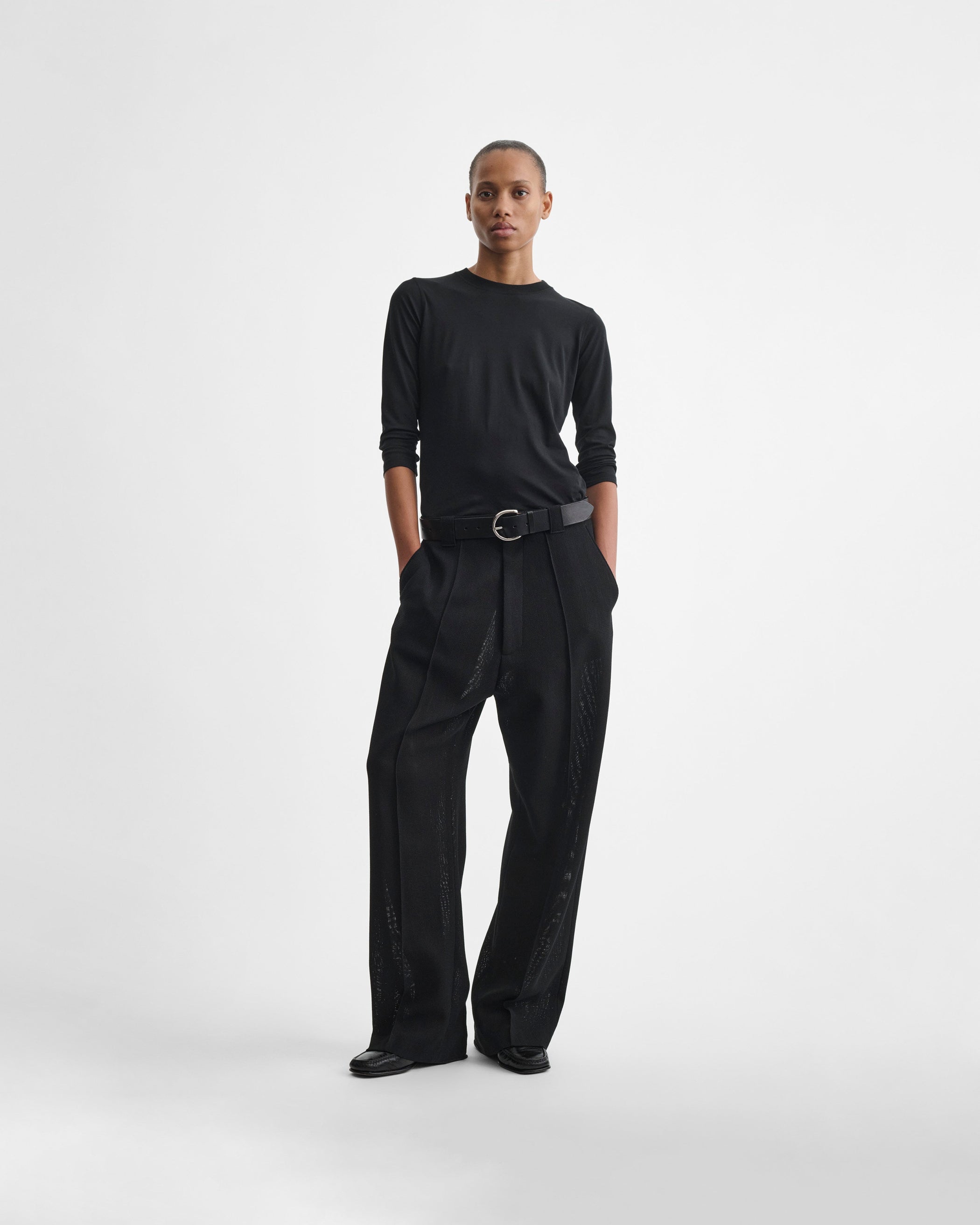 Full length front view of model wearing OVERSIZED TROUSERS in black viscose