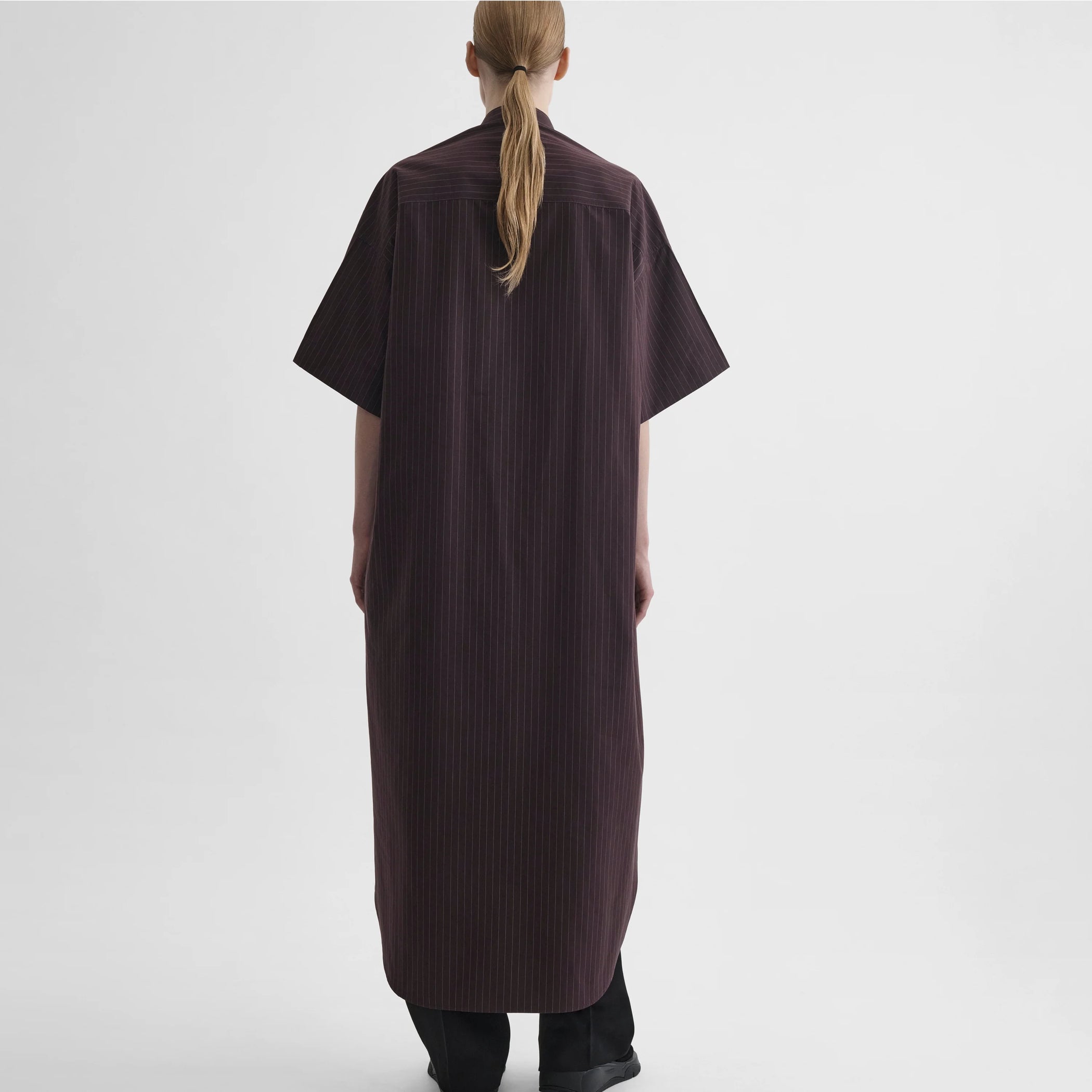 Back full body view of model wearing long shirt dress in black cherry cotton