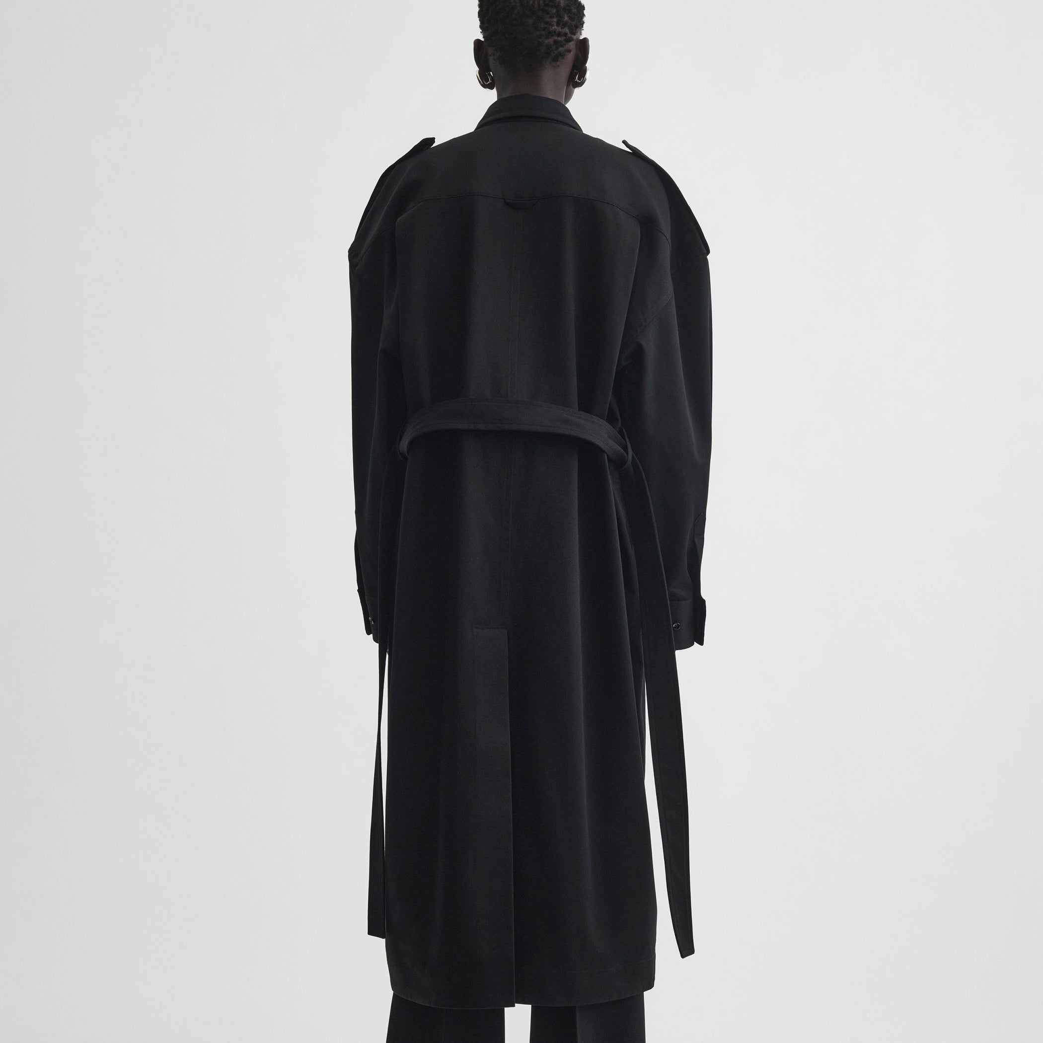 Back view of model wearing UTILITY SHIRT DRESS in black cotton