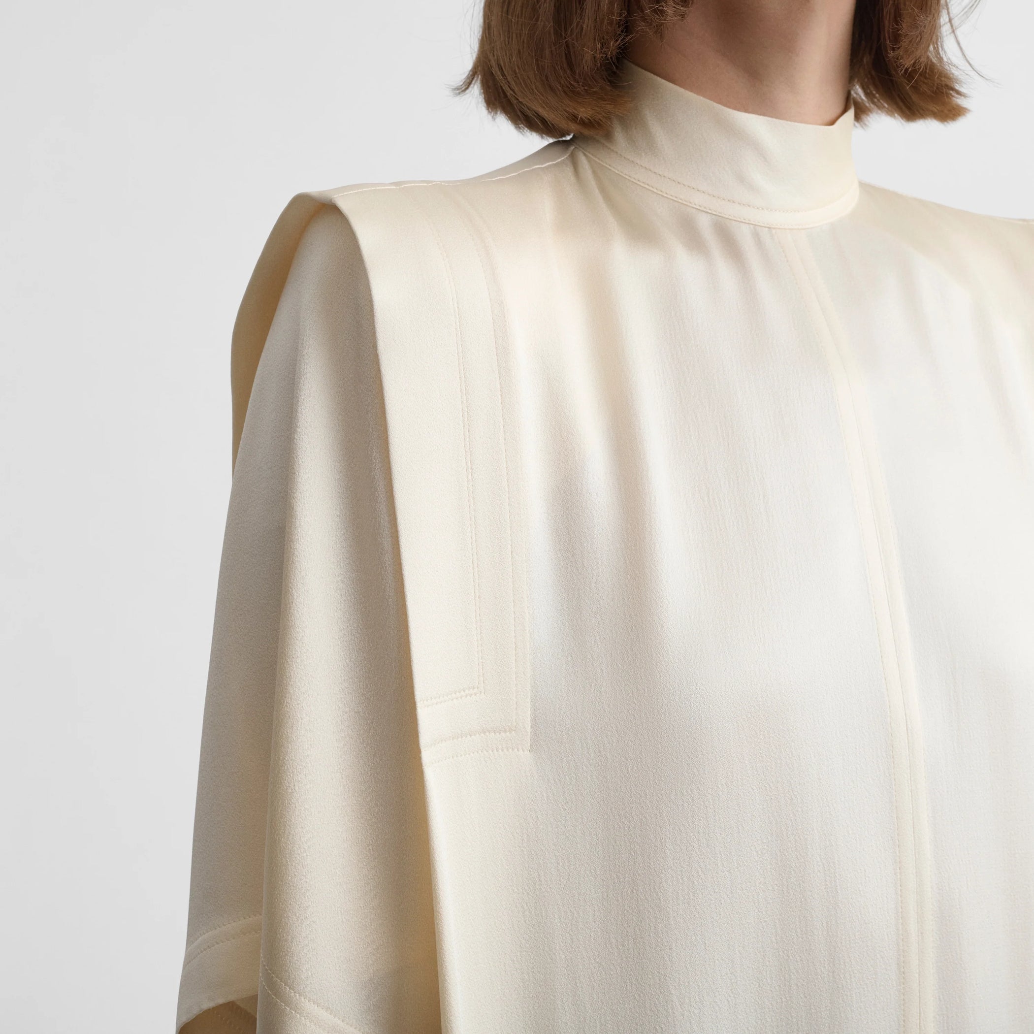 Close up front view of folded shoulder dress in vanilla satin back crepe