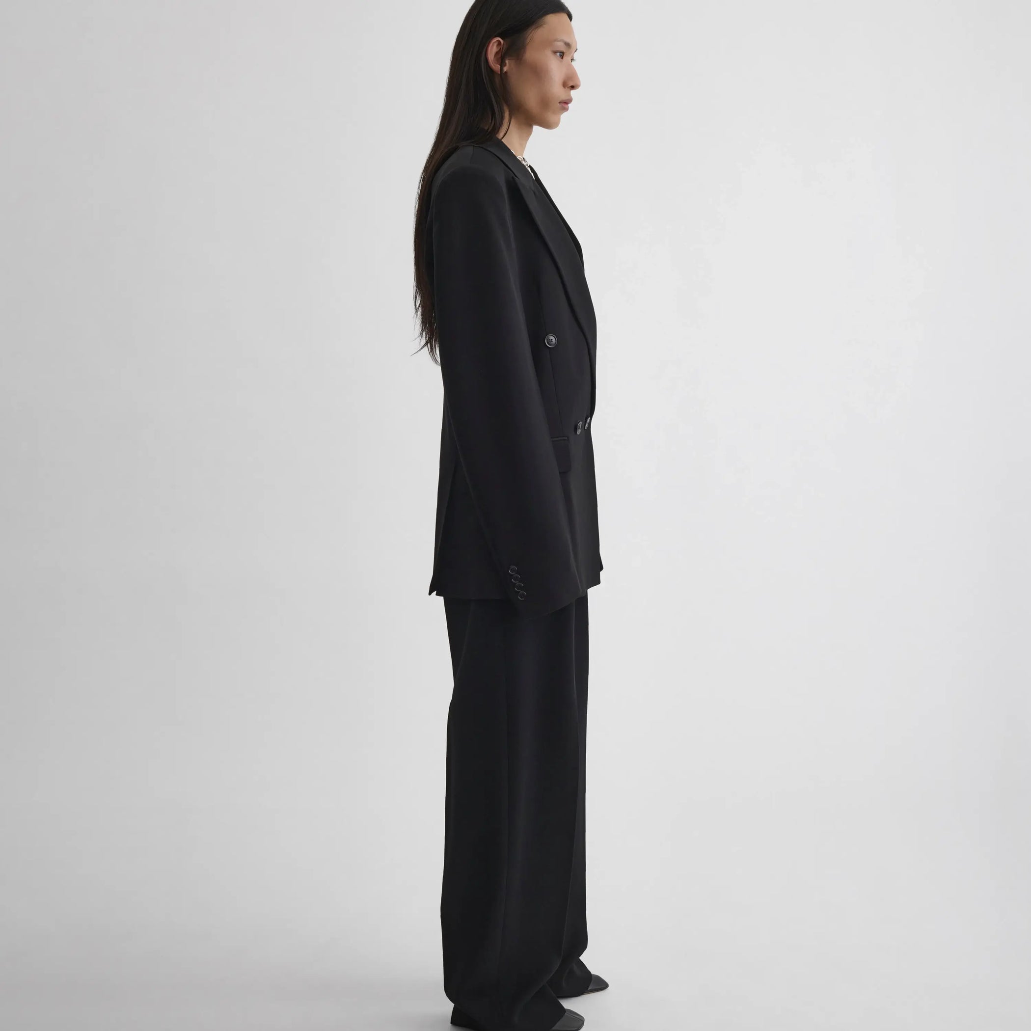 Side view of model wearing Milanese Jacket in black.
