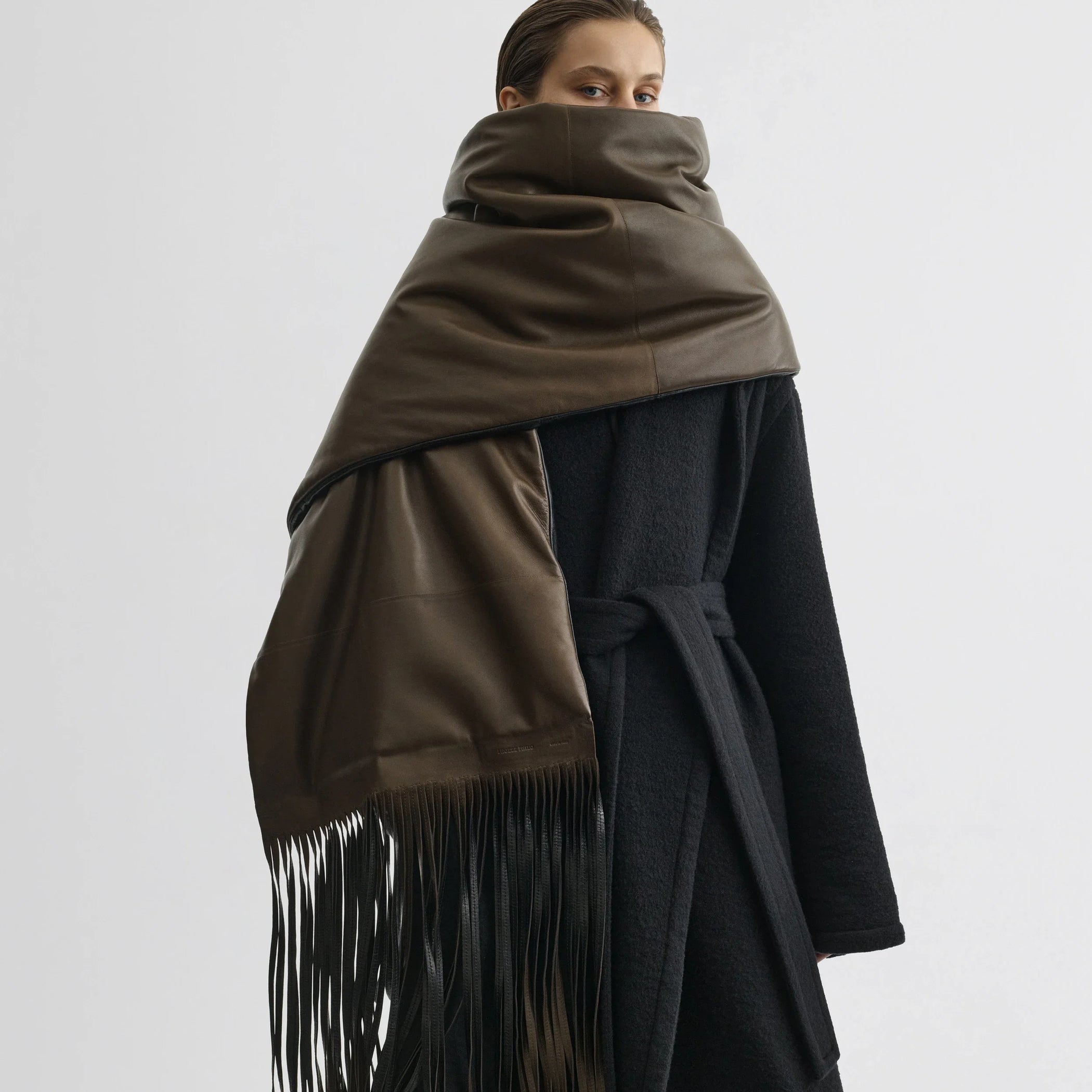 Front view of model wearing padded scarf in olive black leather.