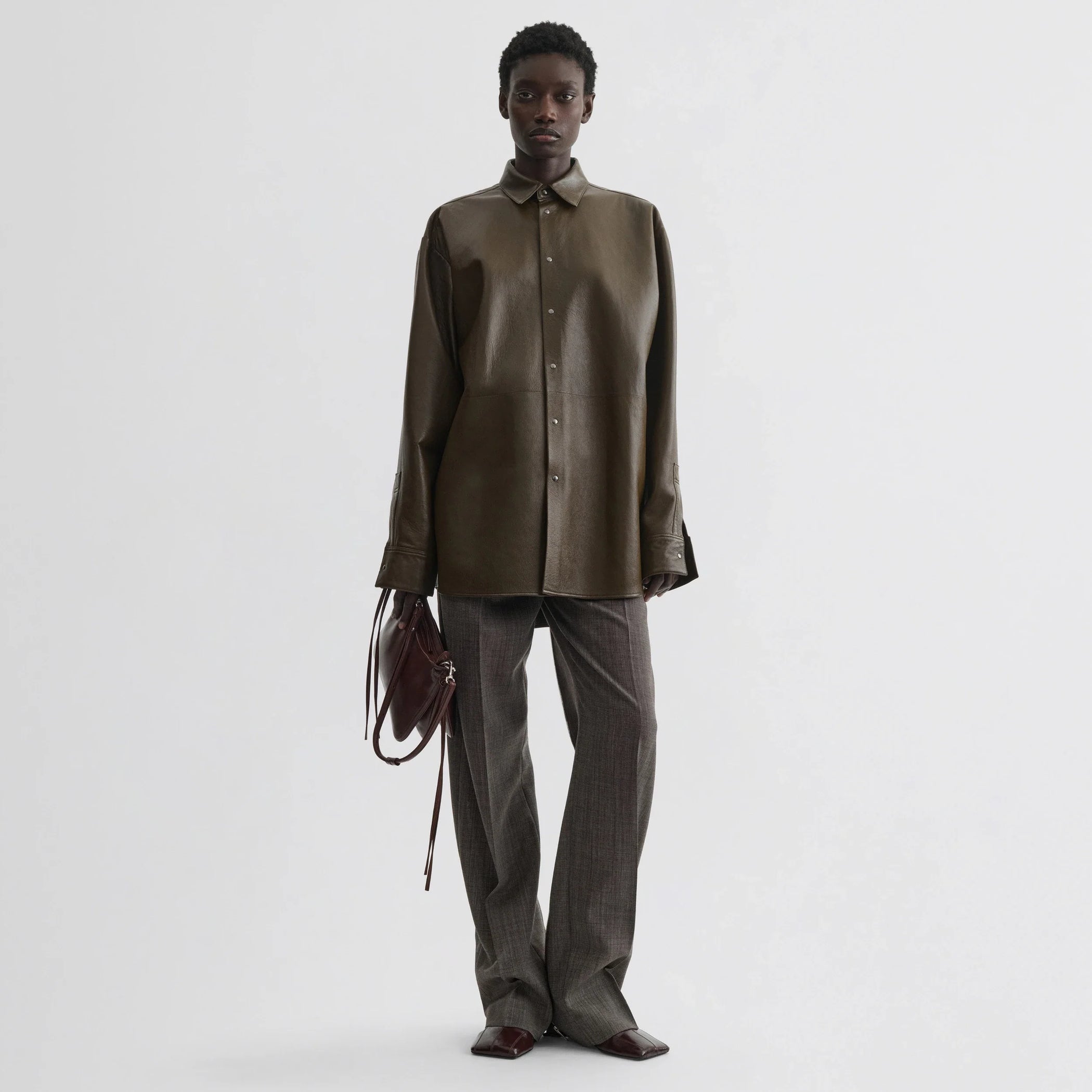 Front view of model wearing overshirt in green bronze leather.