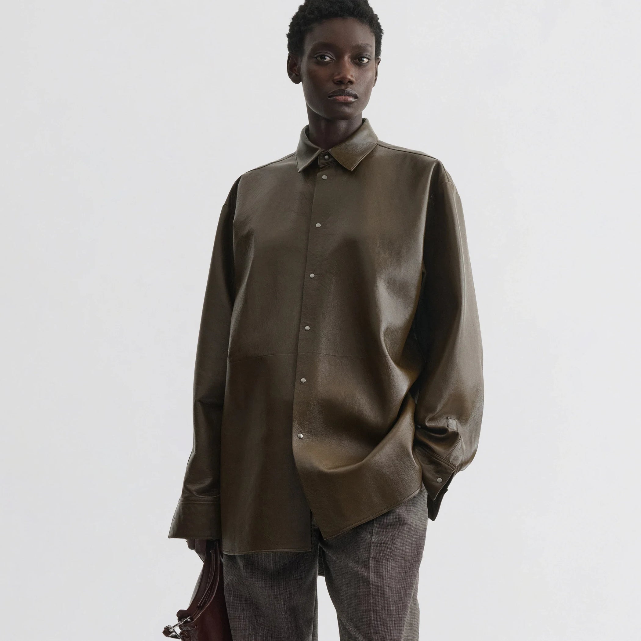 Front view of model wearing overshirt in green bronze leather.
