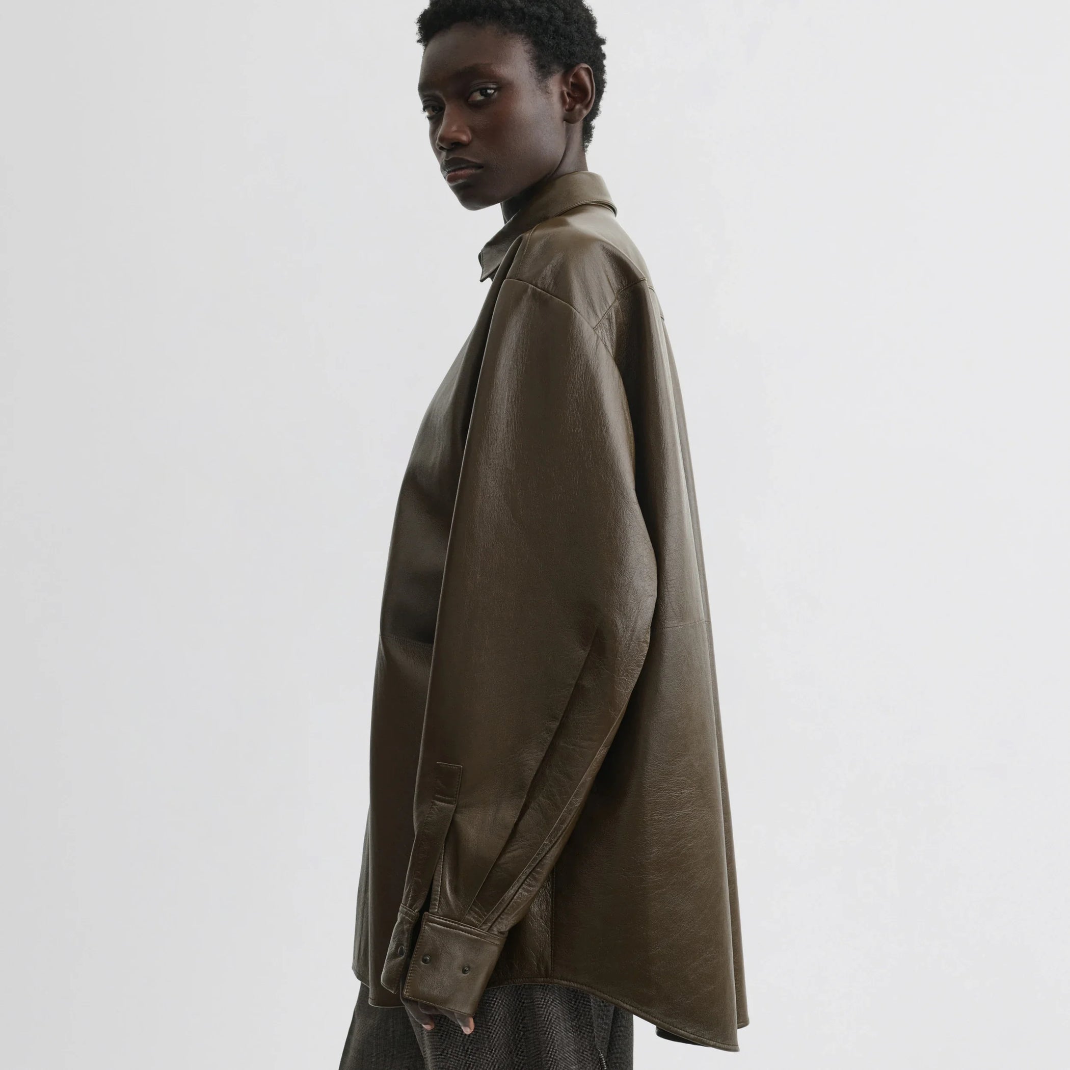 Side view of model wearing overshirt in green bronze leather.