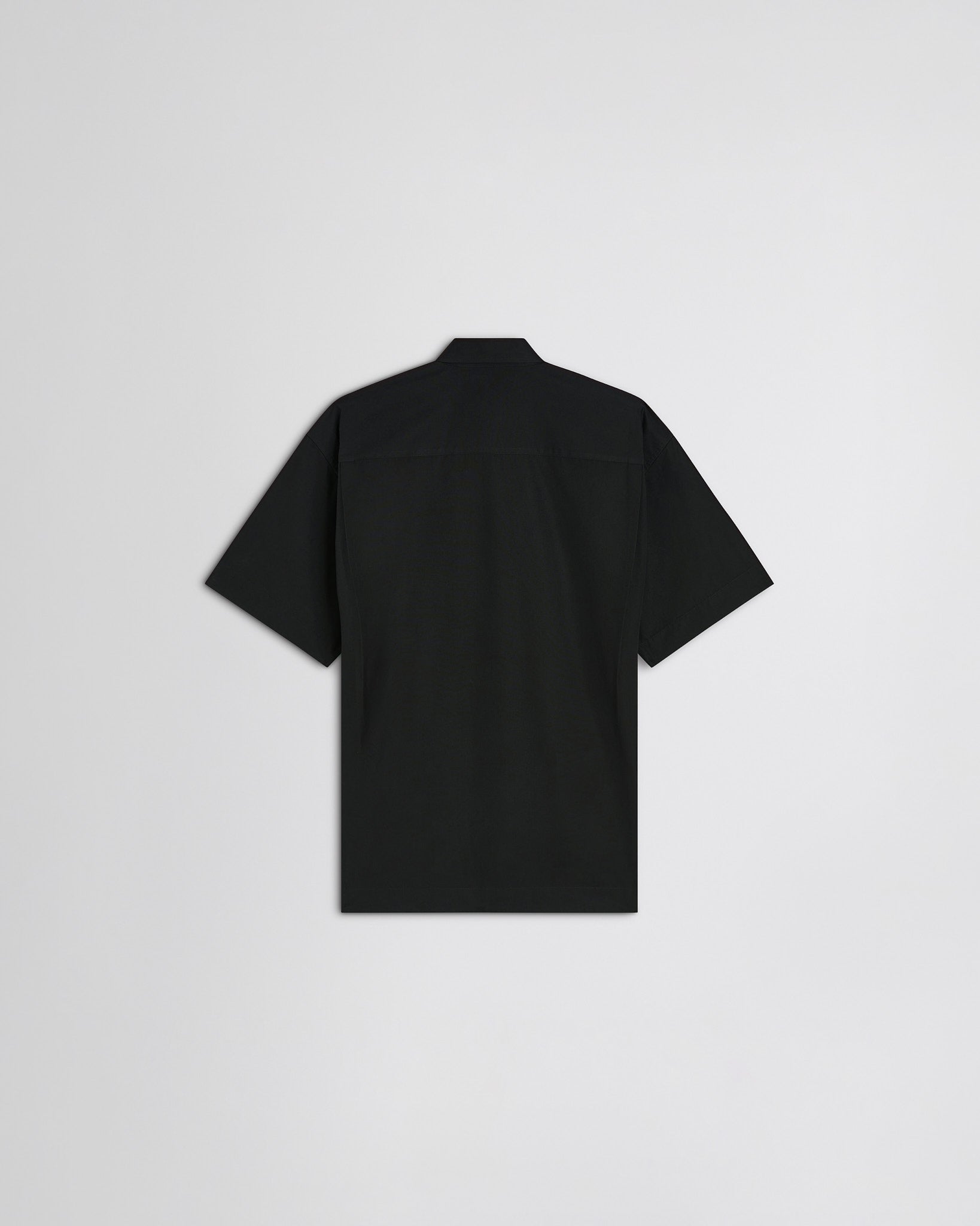 Flat back view of short sleeve shirt in black cotton