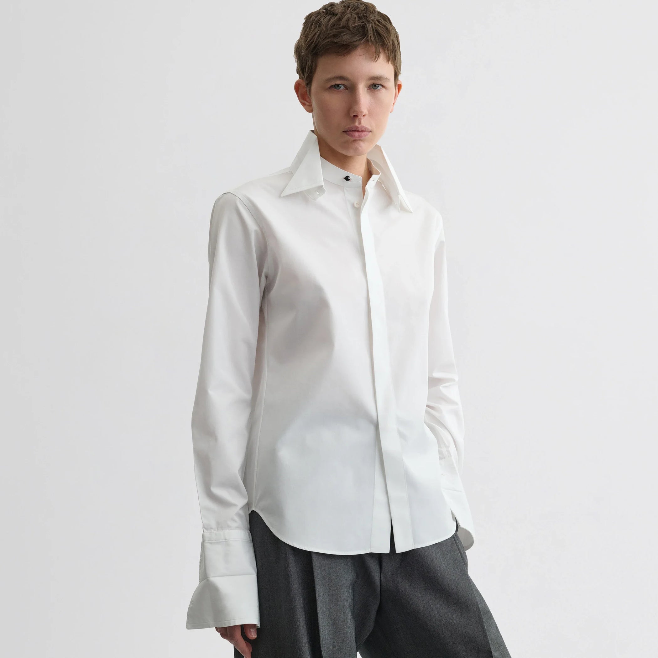 Front view of model wearing tuxedo shirt in white cotton.