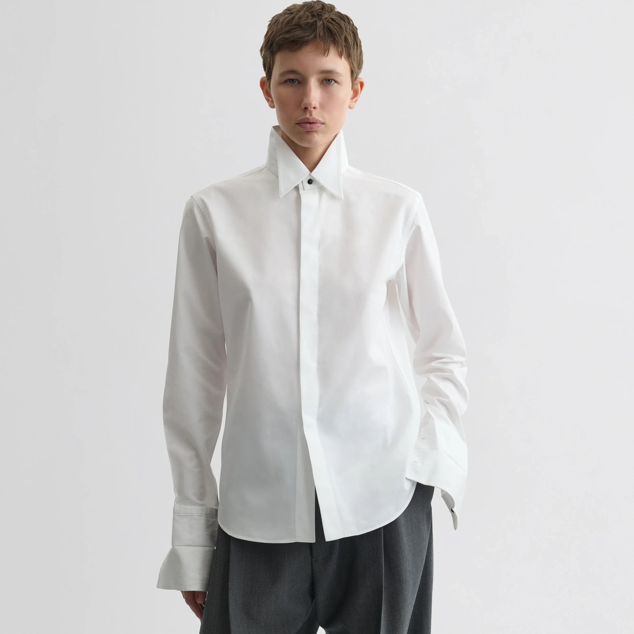 Front view of model wearing tuxedo shirt in white cotton.